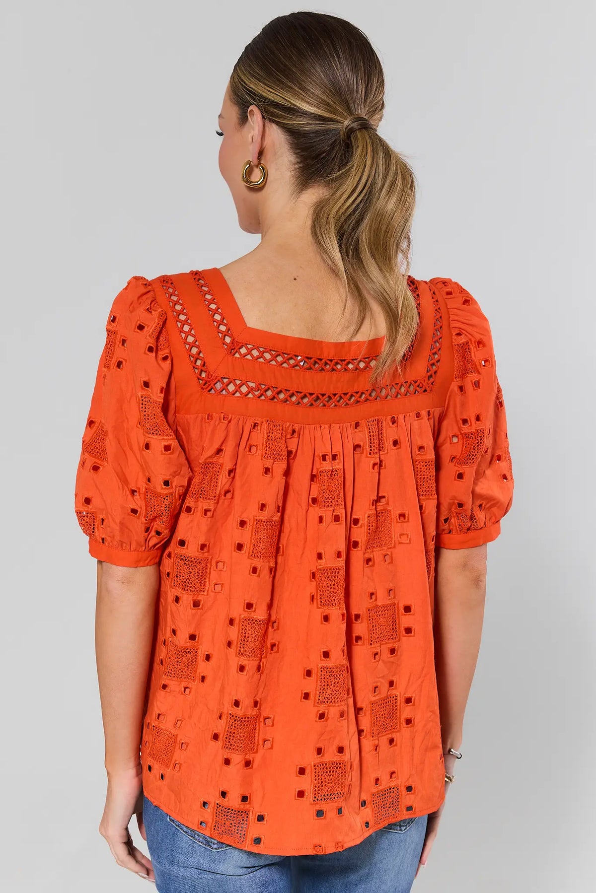 Back view of orange Ines eyelet square neck top showing allover embroidered detail | Avara
