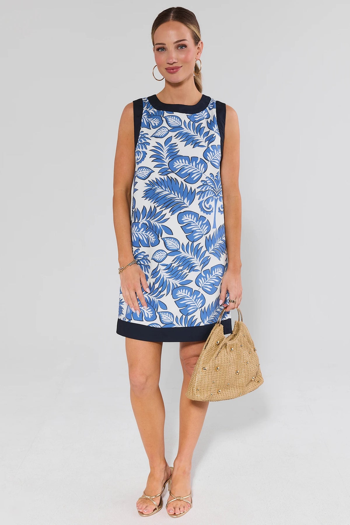 Ester Blue Palm Print Short Dress holding straw bag - Three-Quarter Front View | Avara