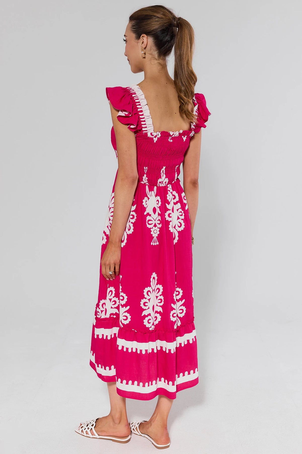 Hot pink abstract print midi dress with smocked back and tiered hem, back view on model | Avara