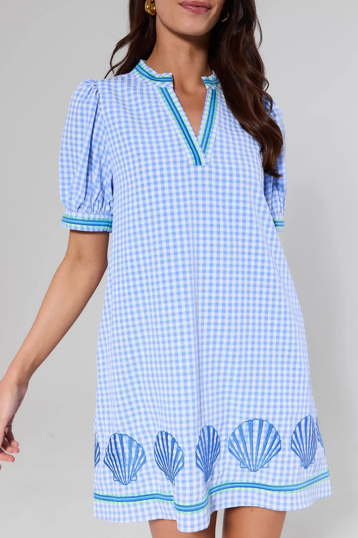 close up Woman wearing a blue and white checkered dress with shell patterns on a gray background