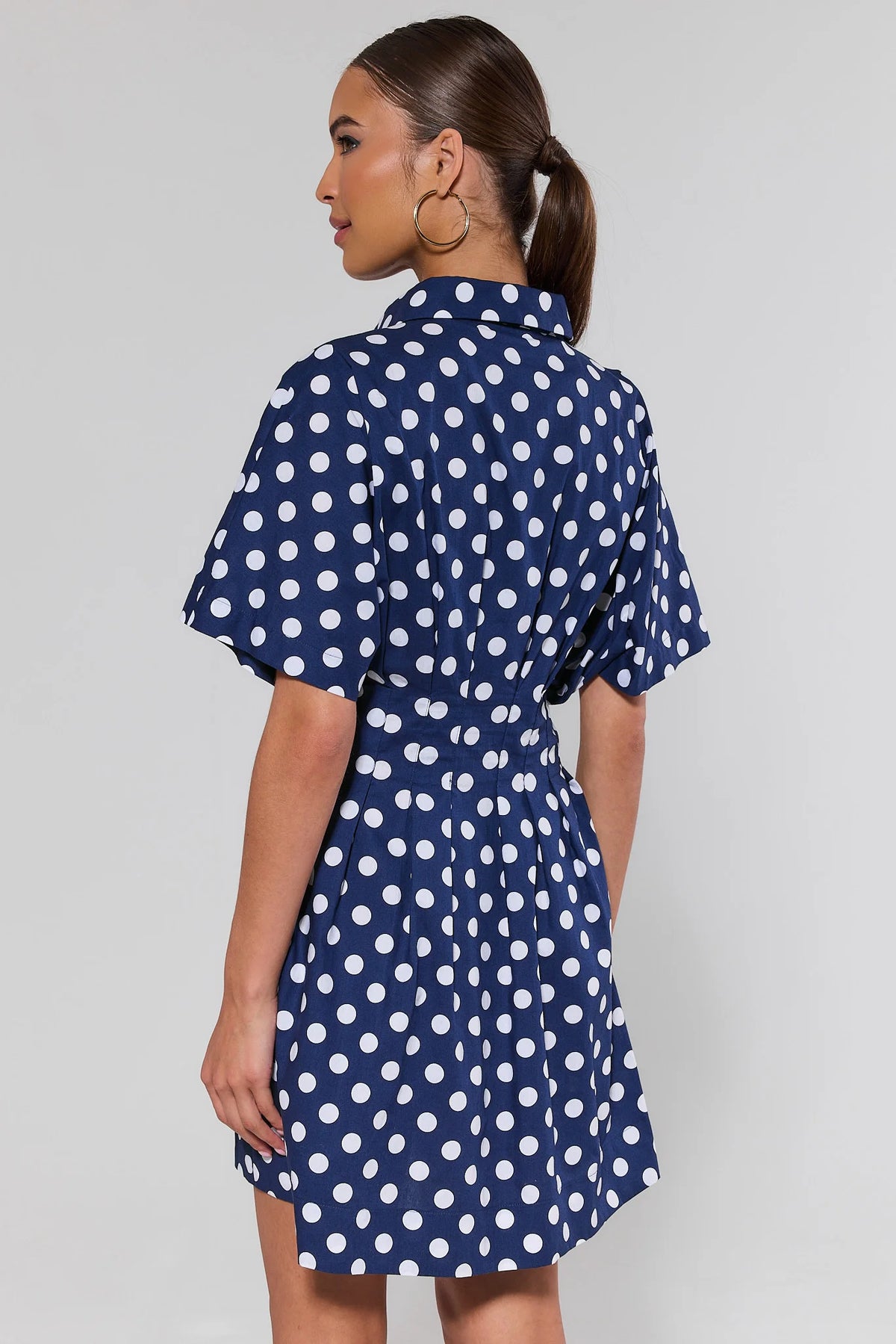 Addison Navy Blue Polka Dot Short Dress - Back View showing pleated skirt and flutter sleeves | Avara