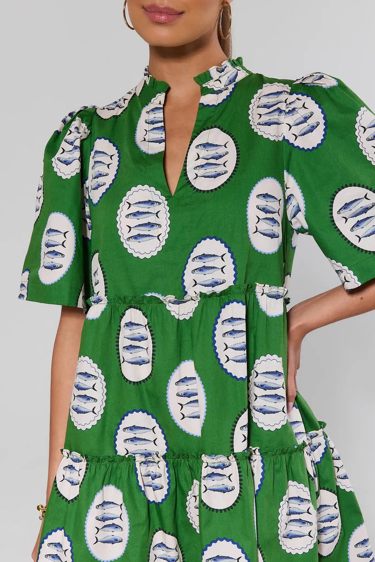 Close-up green sardine print dress with V-neckline and puff sleeves, fabric detail view | Avara