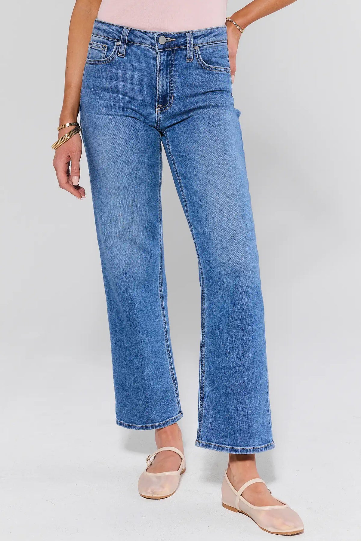 Person wearing blue jeans on a plain background