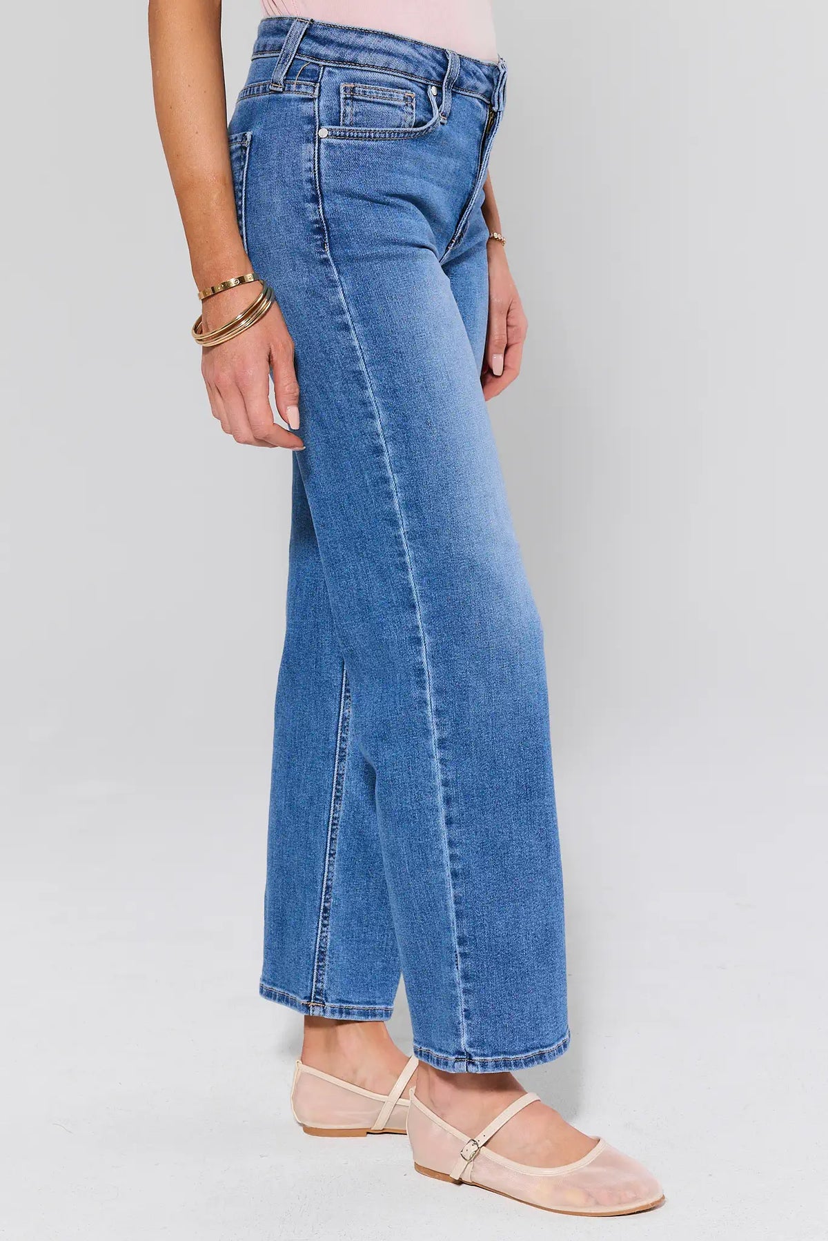Person wearing blue jeans on a plain background