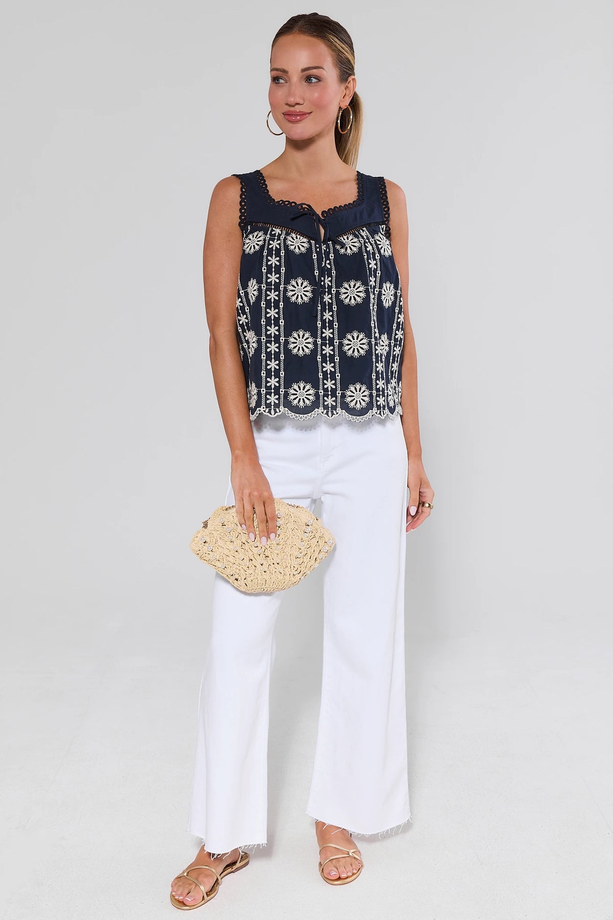 Navy embroidered tank top styled with white wide-leg pants and straw clutch - Full Styled Look | Avara