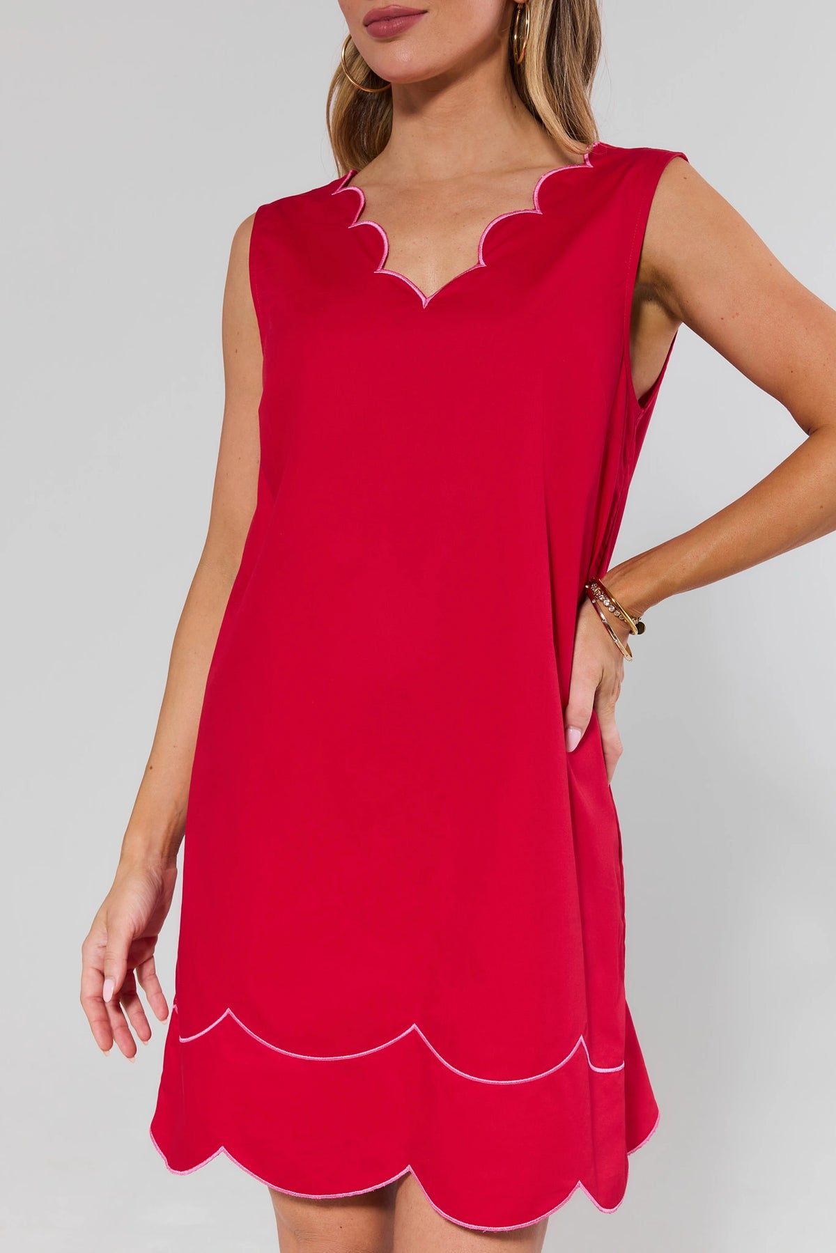 Red scalloped dress with pink contrast trim at neckline and hem - Close-Up Detail | Avara