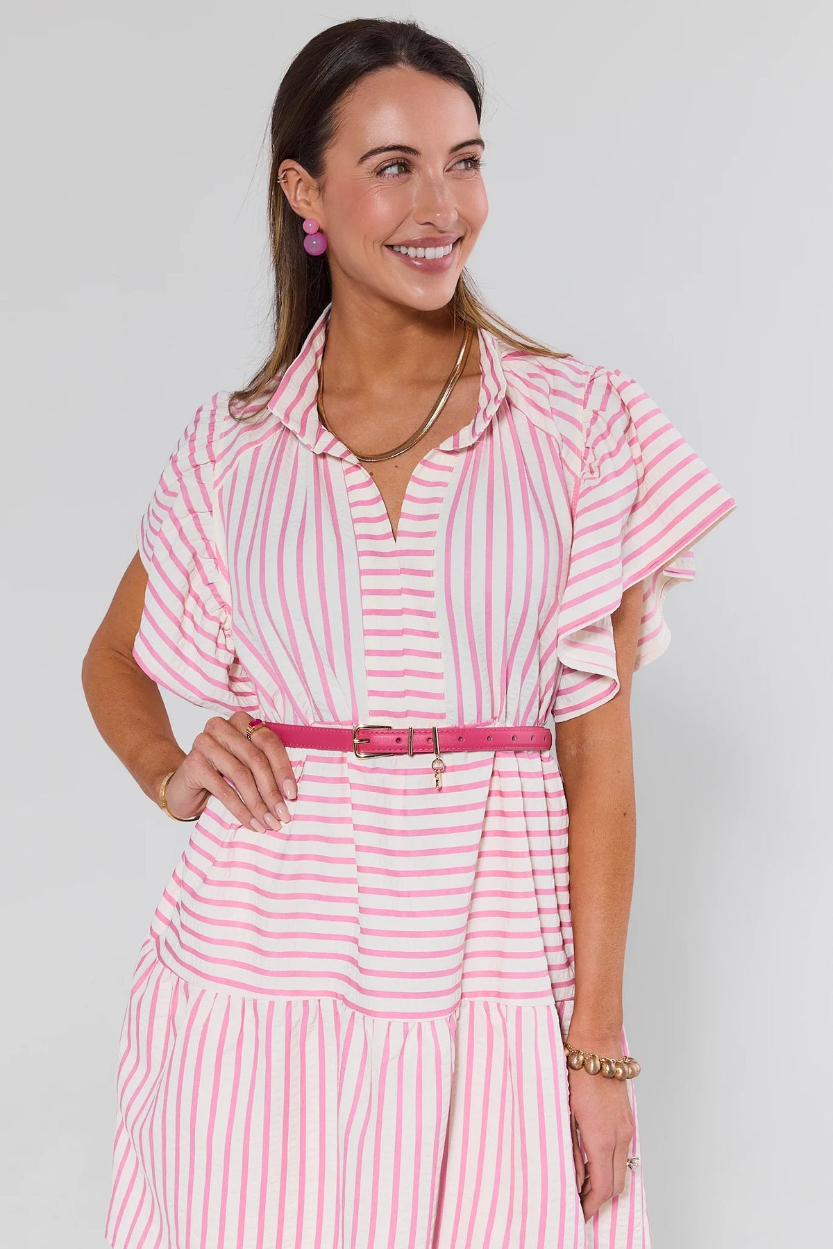 Chelsea Pink Faux Leather Belt styled on model over pink striped dress with gold charm detail | Avara