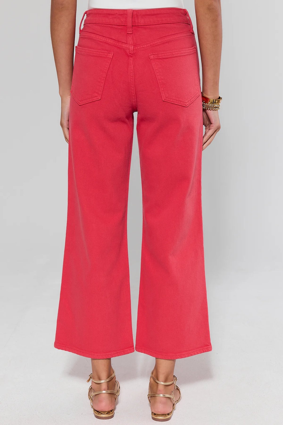Person standing wearing bright pink pants on a white background