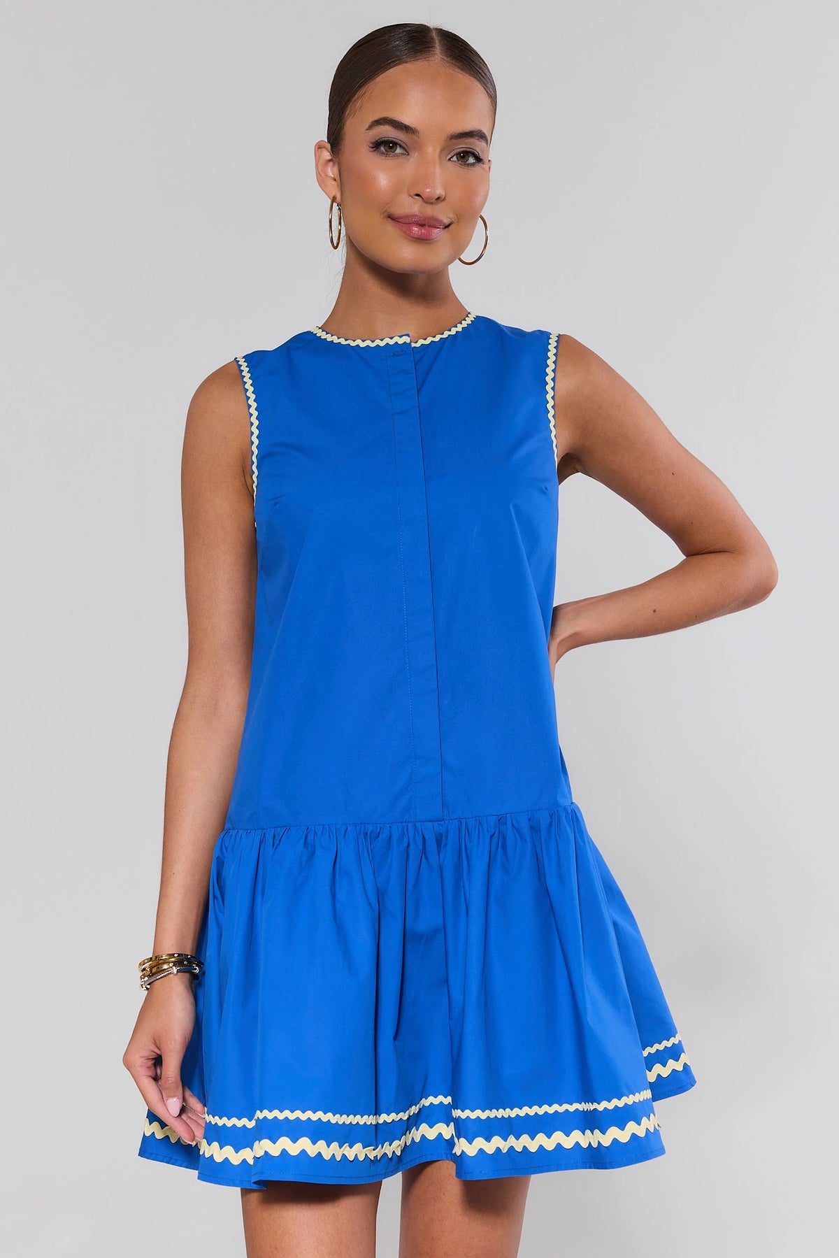 Royal blue drop waist short dress with cream ric-rac trim, front view on model | Avara