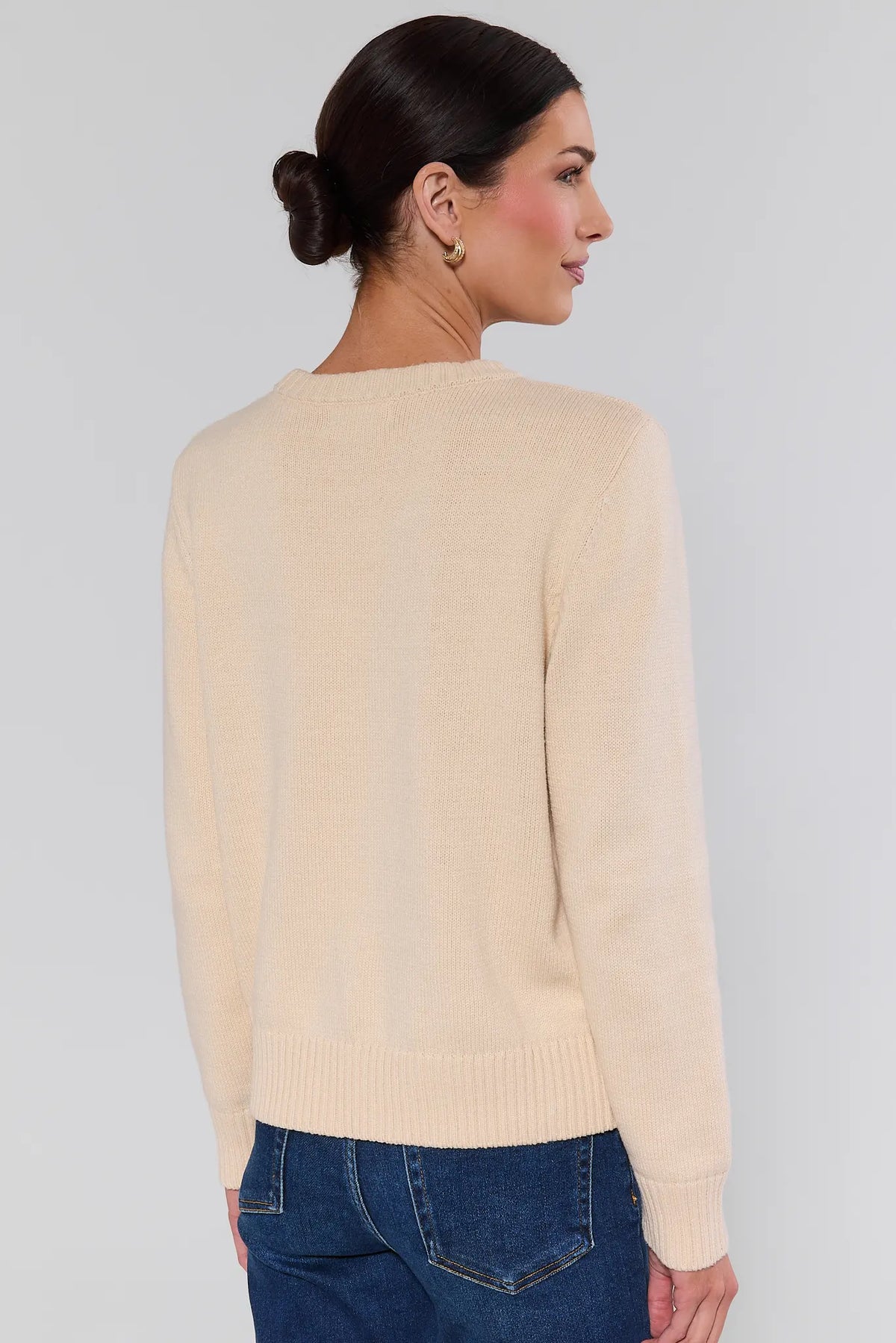Cream American flag knit sweater back view on model, ribbed hem and long sleeves, styled with blue jeans | Avara
