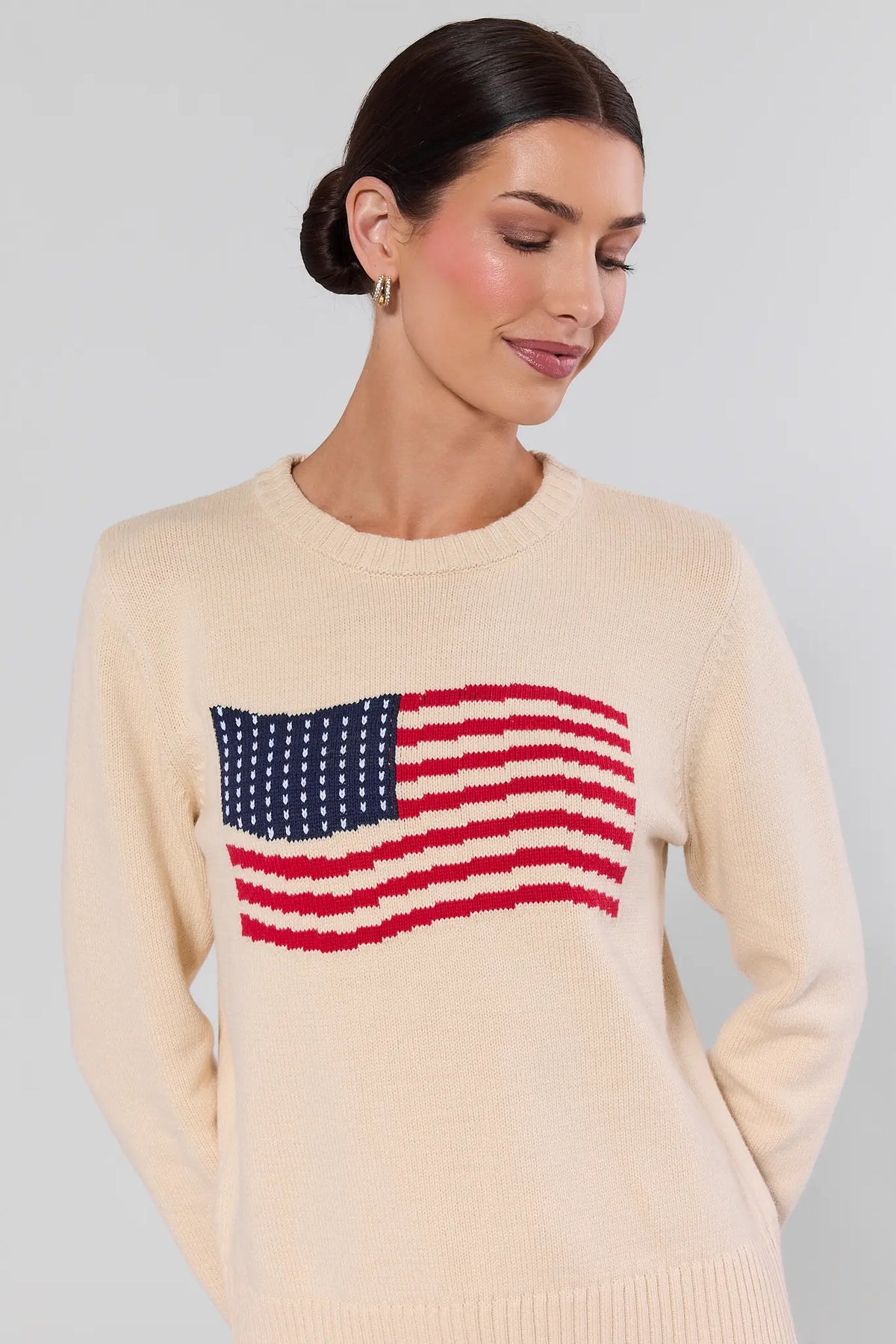 Close-up of cream American flag knit sweater with intarsia-knit flag detail and ribbed crew neckline | Avara
