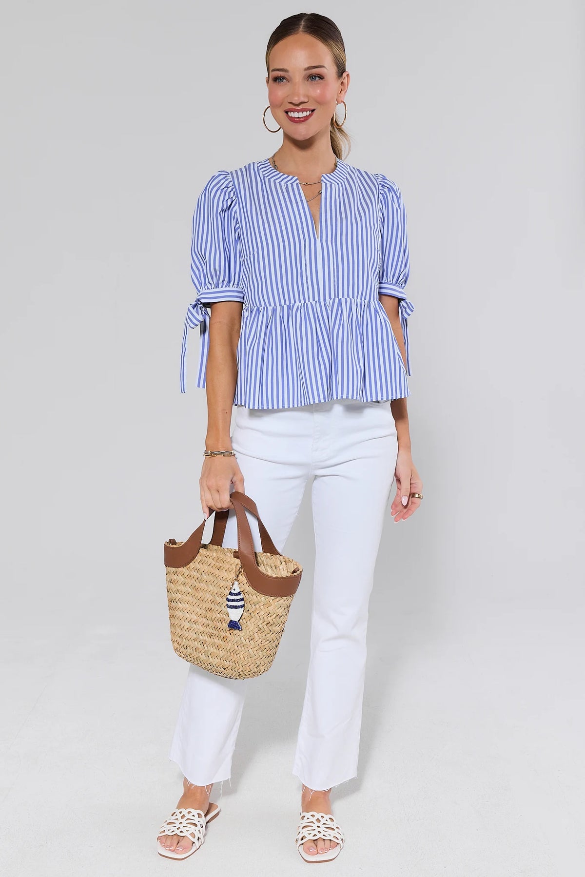 Blue striped peplum top styled with white jeans and straw tote - Full Outfit View | Avara