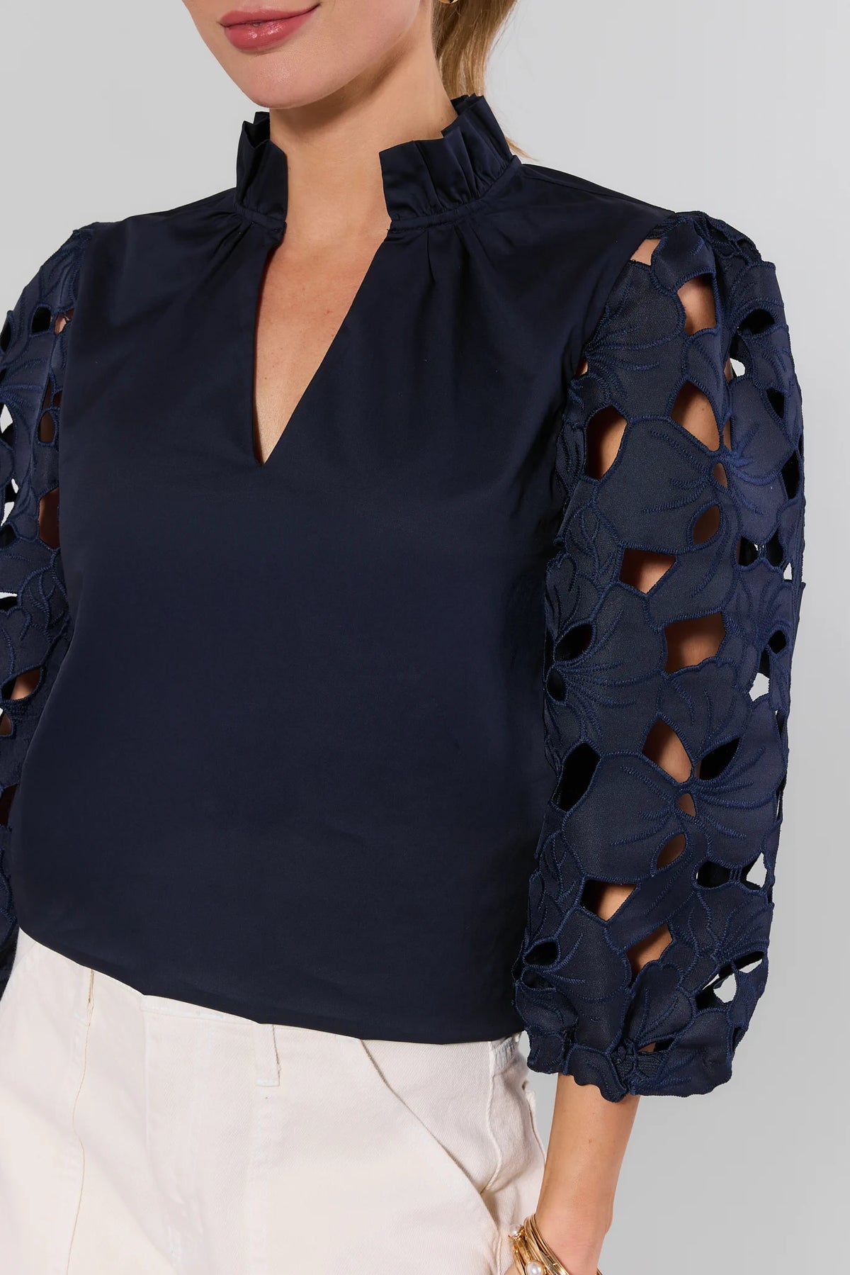 Navy eyelet blouse by THML featuring cutout embroidered sleeves and ruffled V-neckline - Close-Up Detail | Avara