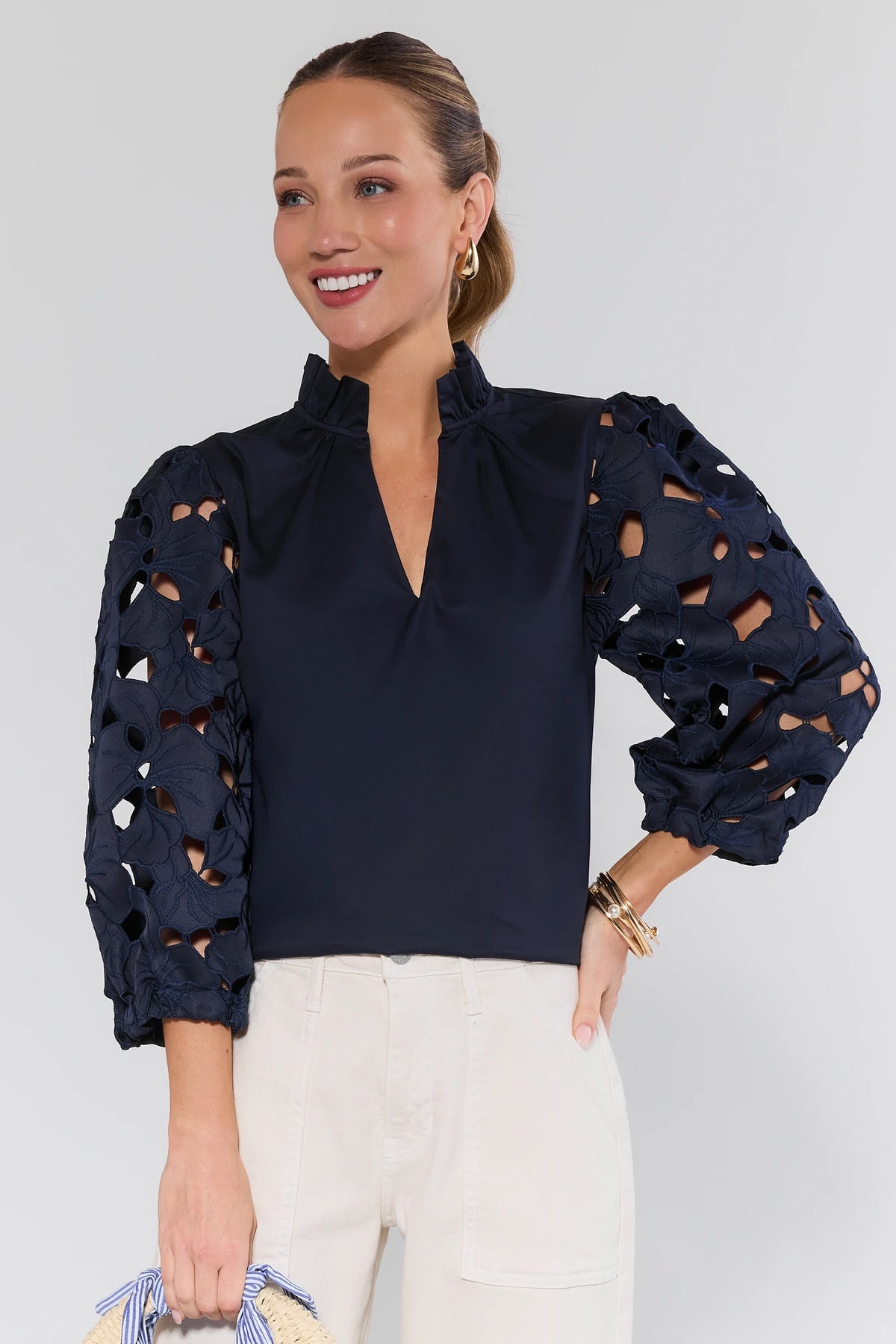 Navy eyelet sleeve top by THML with ruffled collar and cutout three-quarter sleeves, styled with cream pants - Front View | Avara