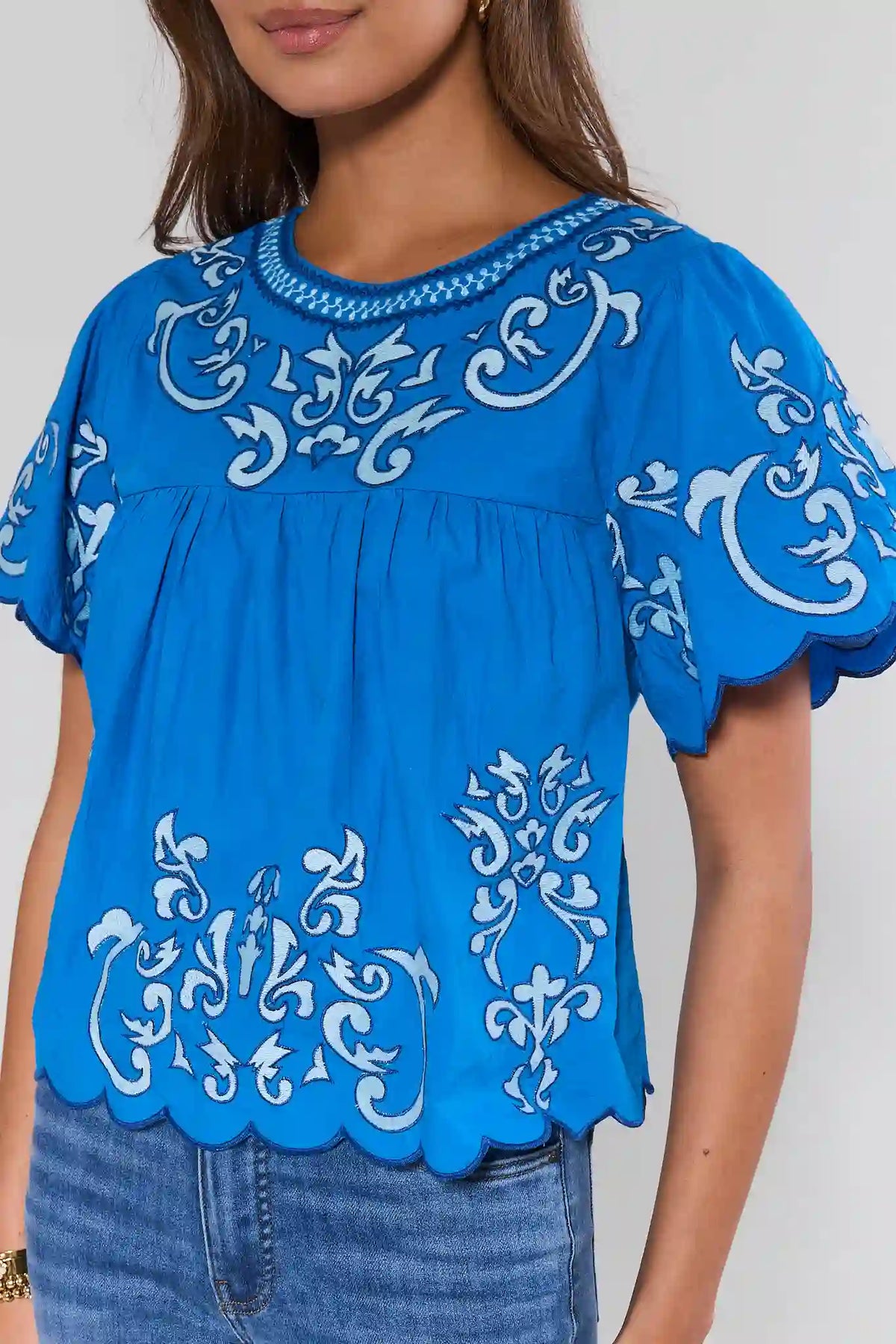 Blue scalloped hem blouse with white scroll embroidery and neckline detail - Close-Up | Avara