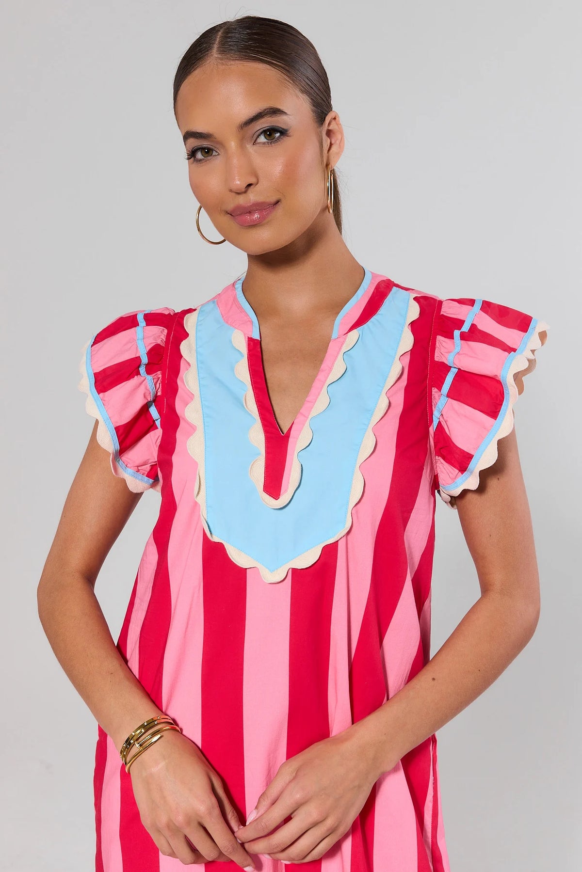 THML pink striped midi dress close-up showing scalloped blue bib neckline and ruffle sleeve detail | Avara