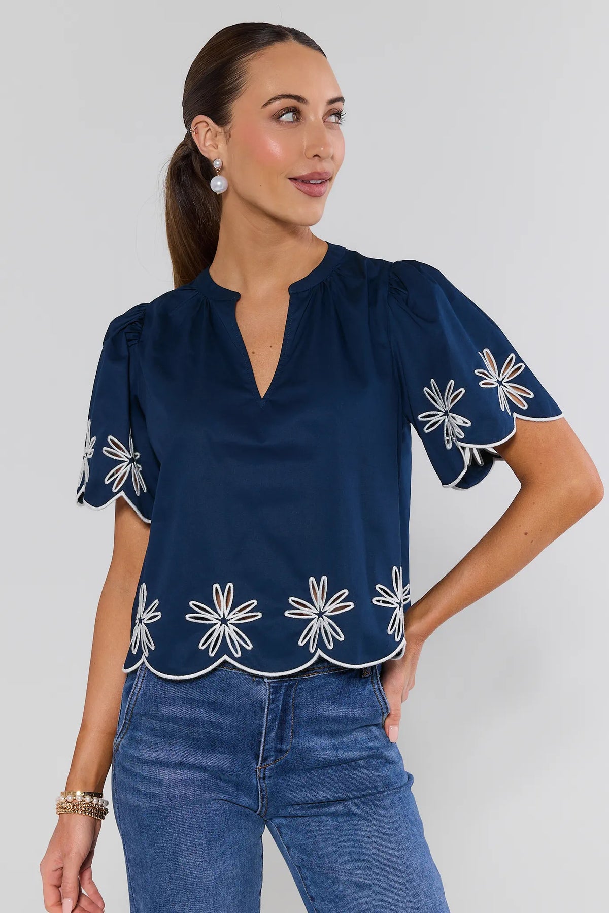 Navy embroidered trim top with white daisy eyelet scalloped hem, puff sleeves, split neckline - Front View | Avara