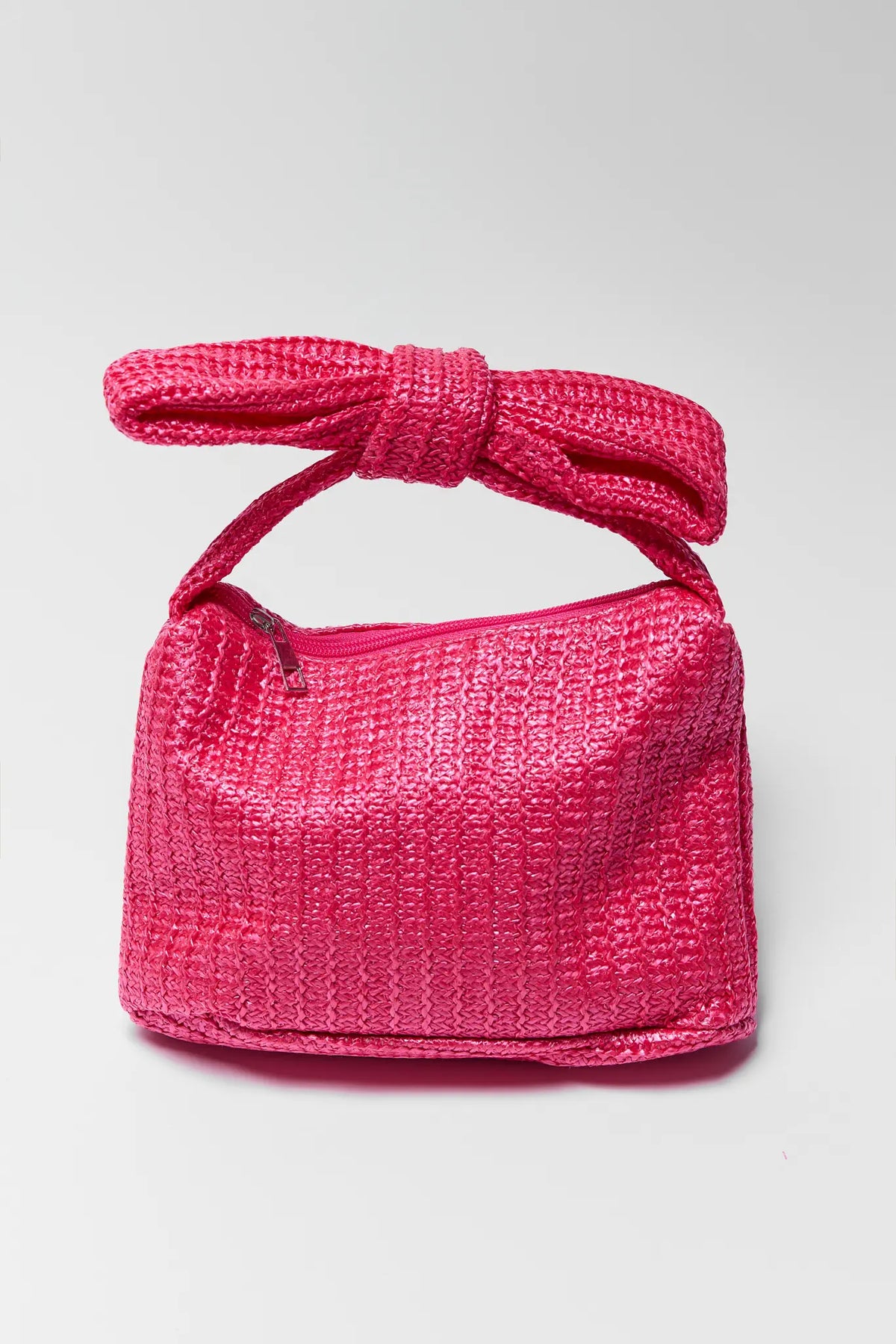 Hot pink woven raffia bow clutch with top handle - Front View | Avara