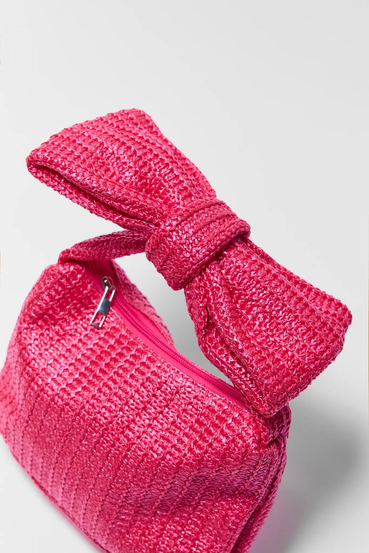 Hot pink raffia clutch bag bow handle and zipper close-up - Texture Detail | Avara