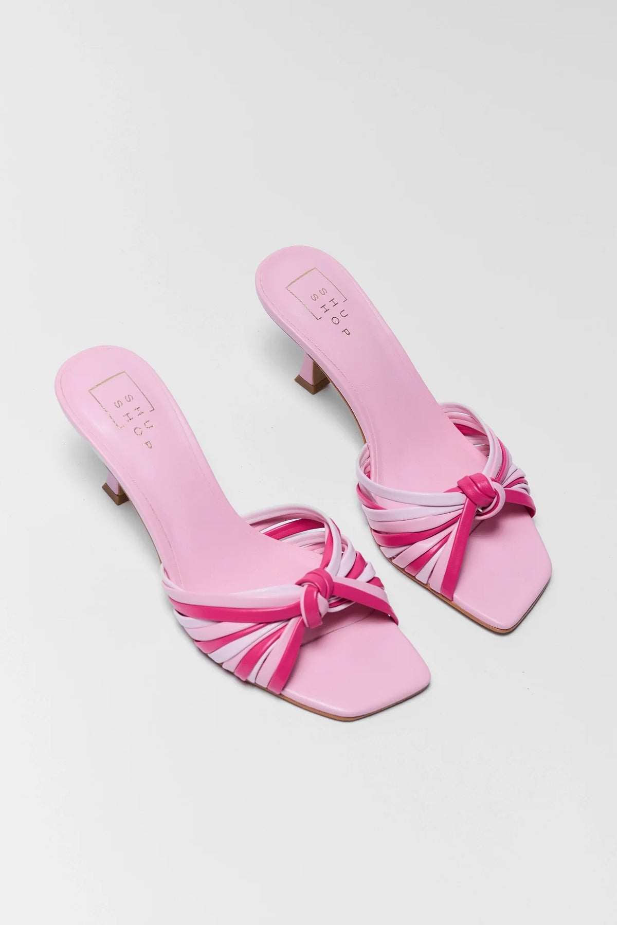 Pair of pink kitten heel sandals with fuchsia multi-strap knot - Angled Flat Lay | Avara