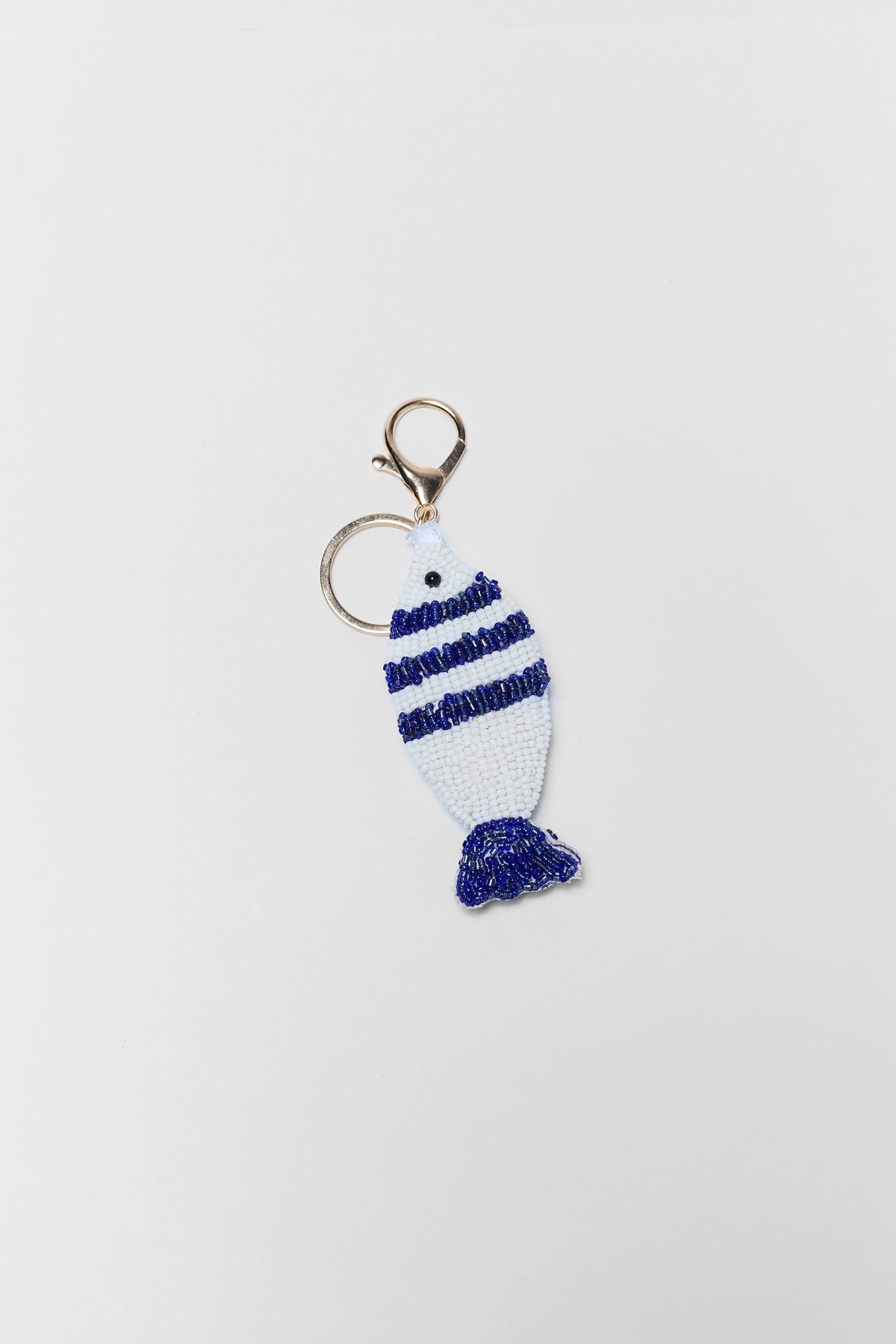 White & Blue Striped Beaded Fish Bag Charm with Gold Lobster Clasp - Flat Lay | Avara