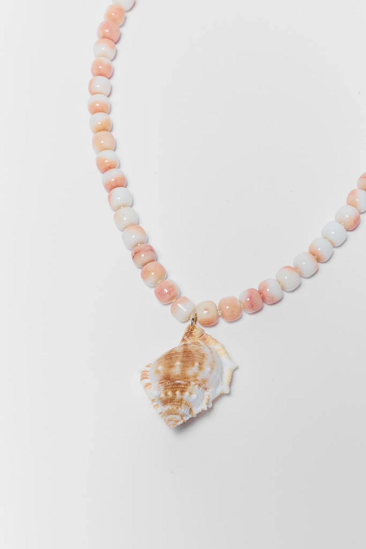 close up Necklace with shell pendant and pink beads on a white background