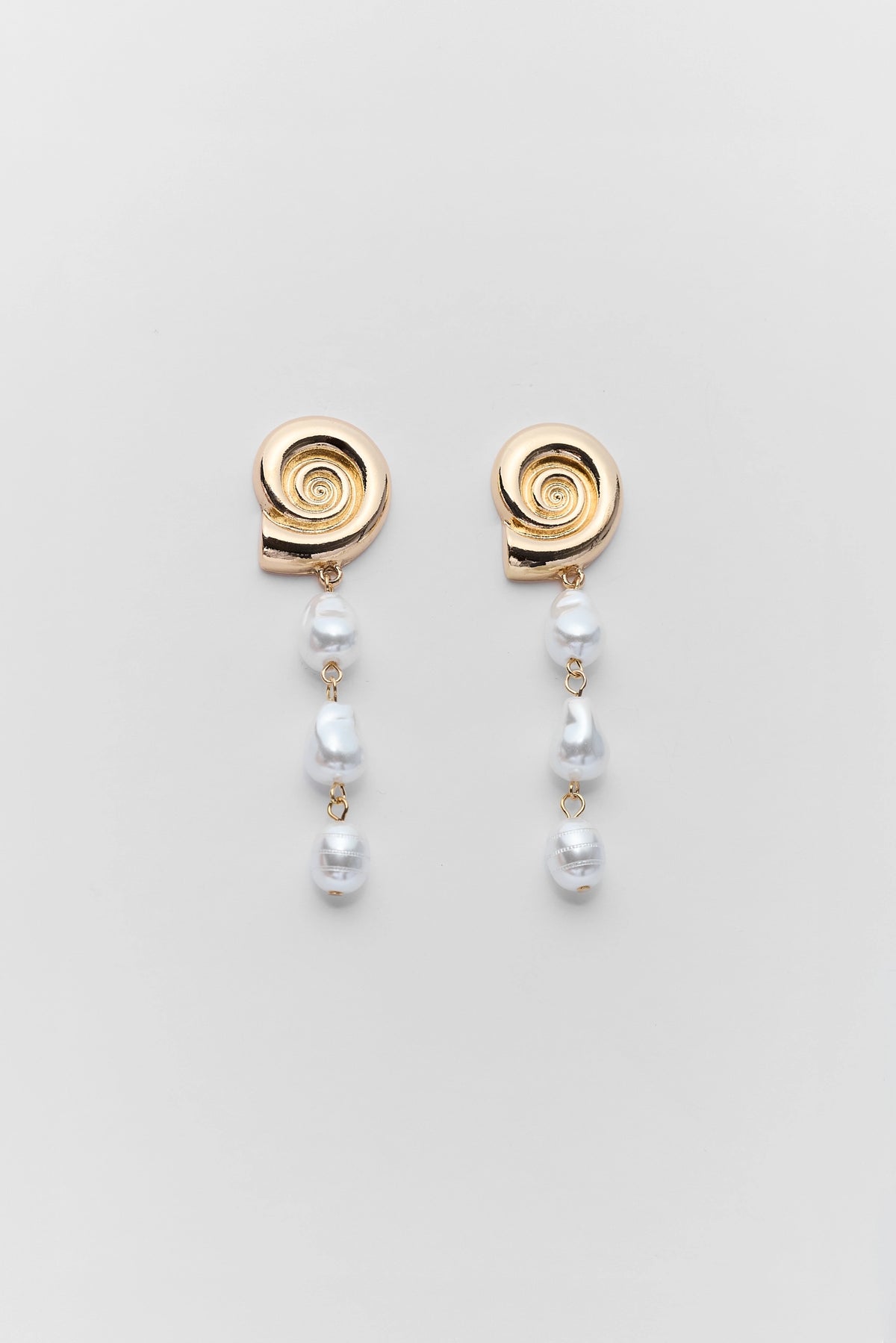Gold shell pearl drop earrings with spiral shell top and dangling pearl beads - Flat Lay | Avara