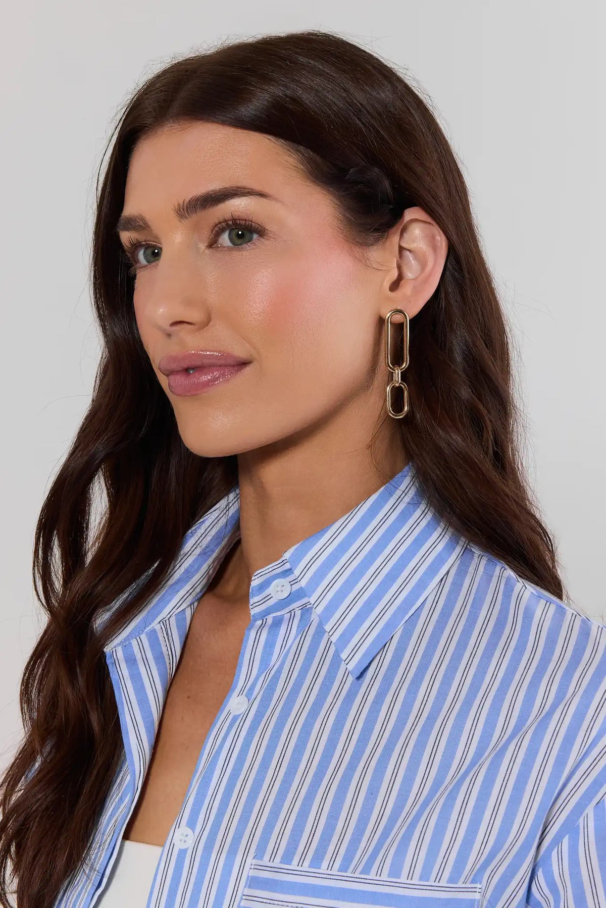 Woman wearing a blue striped shirt against a plain background