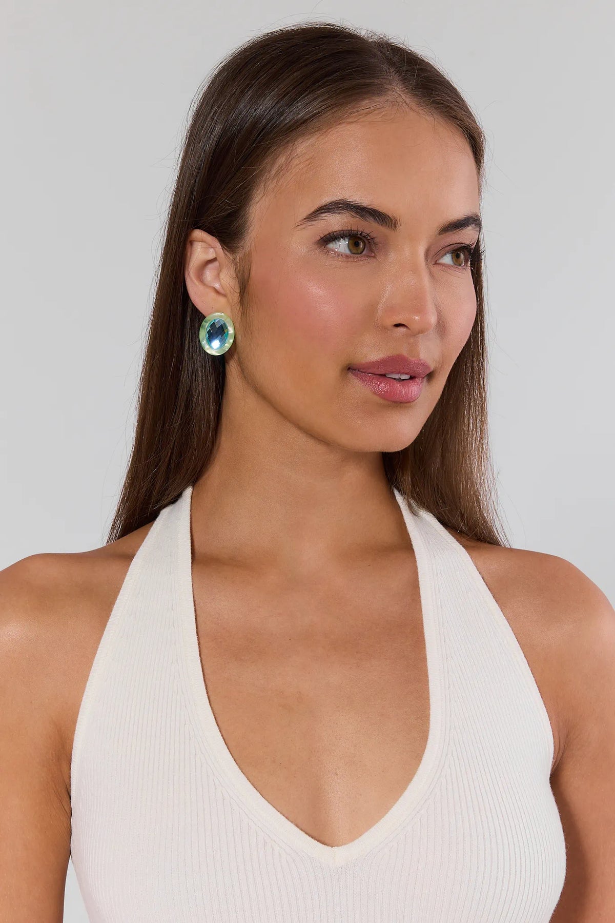 Woman wearing a white halter top against a plain background
