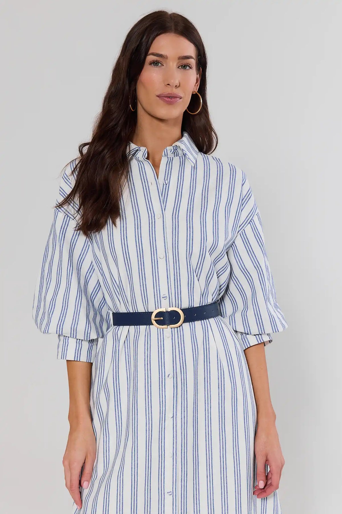 Women's navy blue leather belt styled over white striped dress with gold buckle - On Model | Avara