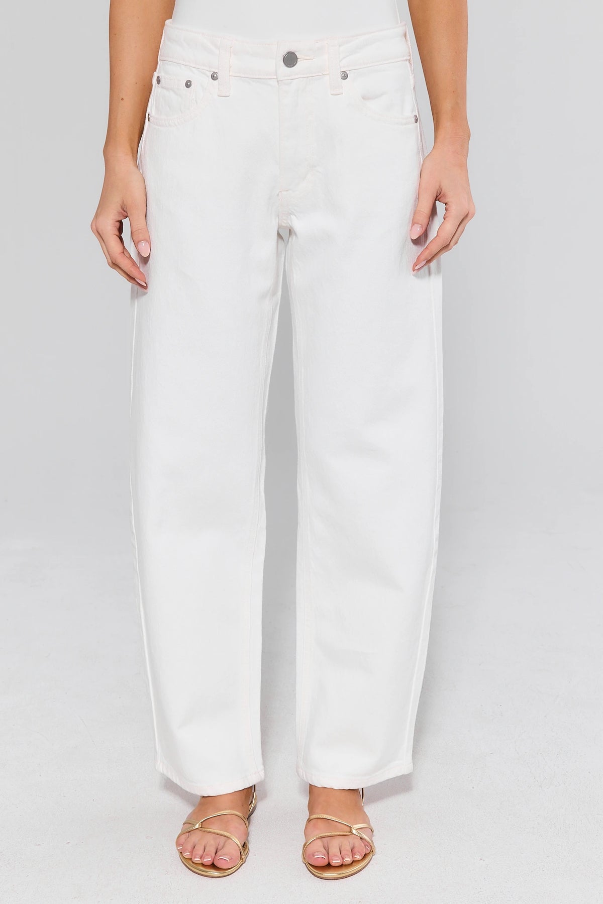 White barrel leg jeans on model with gold sandals, front view | Avara