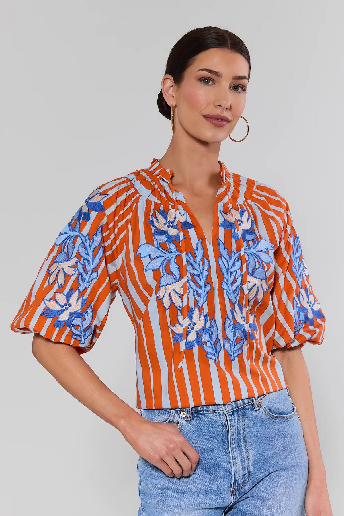 Orange striped embroidered top by THML with blue floral stitching, puff sleeves, on model - Front View | Avara