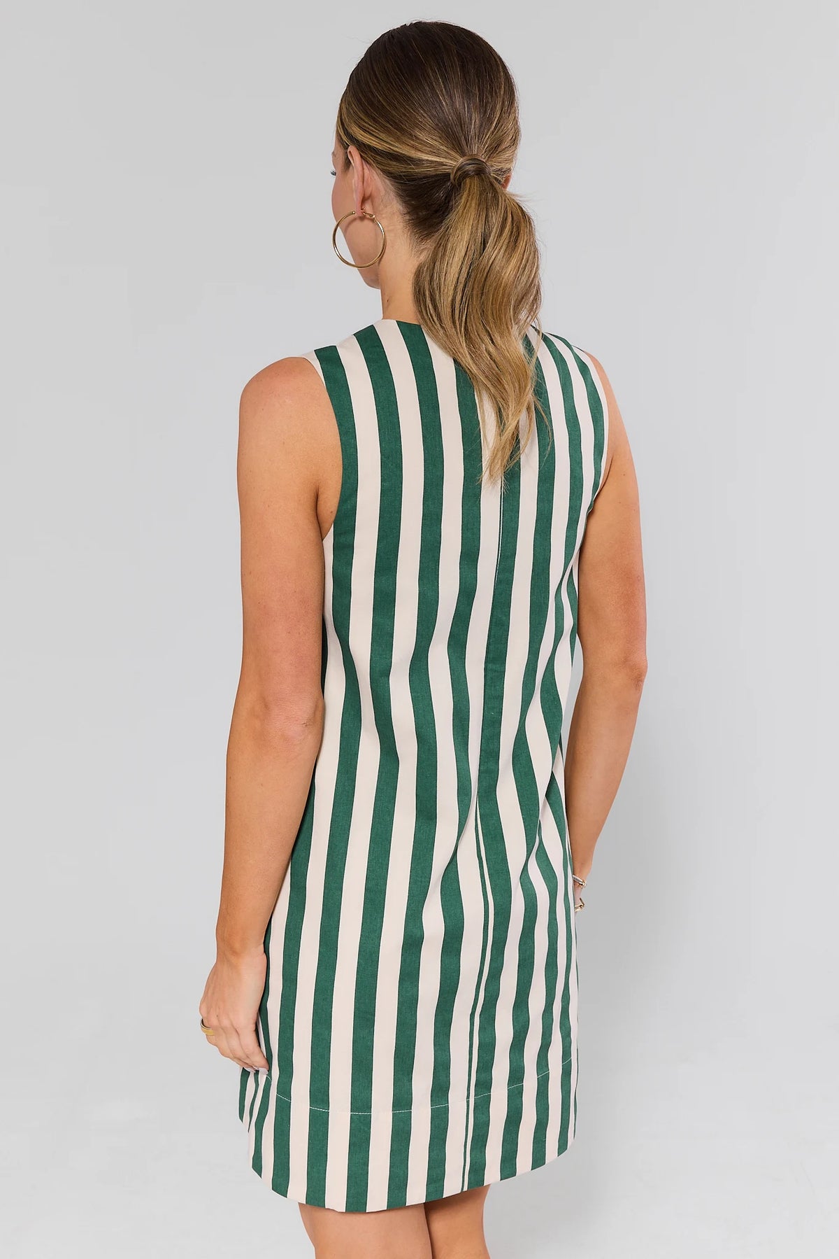Back view of green and white striped sleeveless short dress showing clean seam and hem | Avara