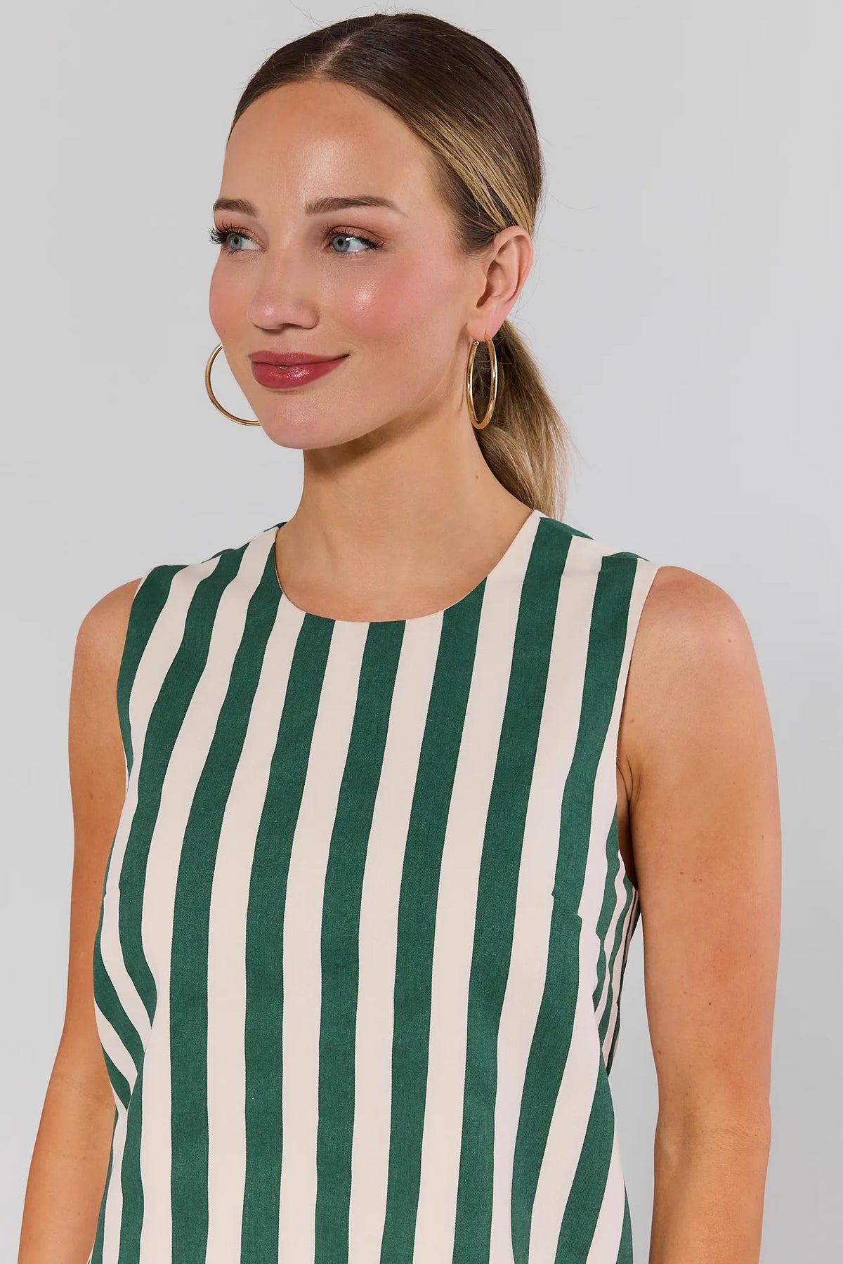 Close-up of green and white striped sleeveless dress, crew neckline detail, on model | Avara