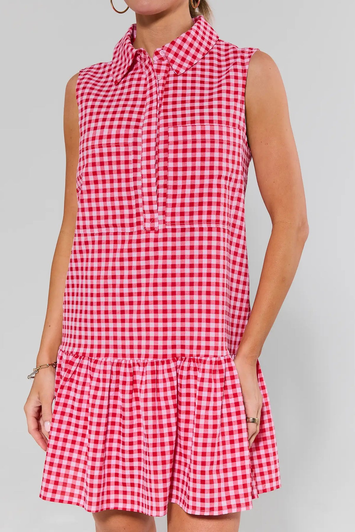 Close-up of red and white gingham short dress showing collar, button placket, and tiered ruffle hem | Avara