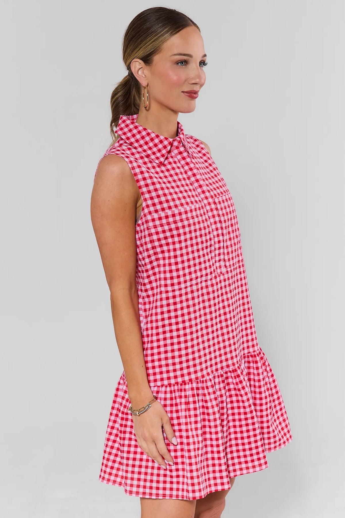 Side profile of red gingham drop-waist short dress with sleeveless collar and ruffle hem - Side View | Avara