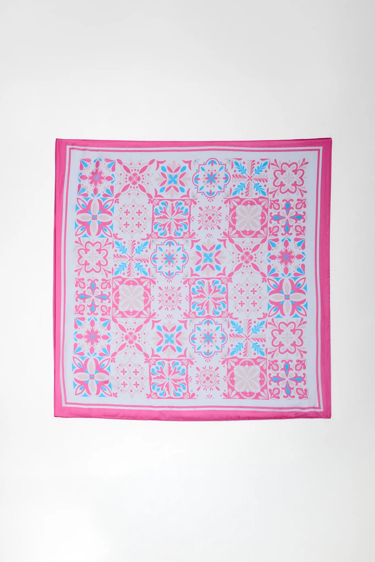 Pink and blue patterned square scarf on a white background