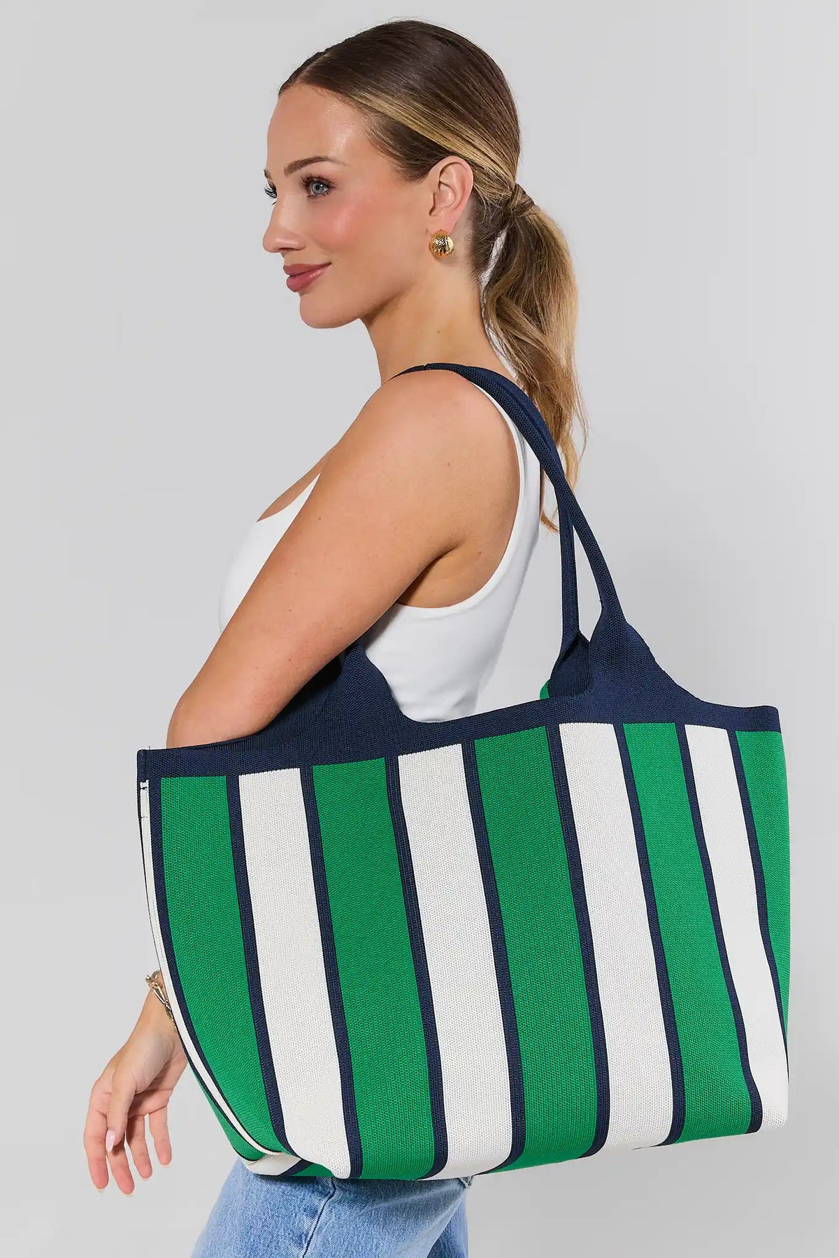 Woman carrying green striped woven tote bag on shoulder - On Model Side View | Avara