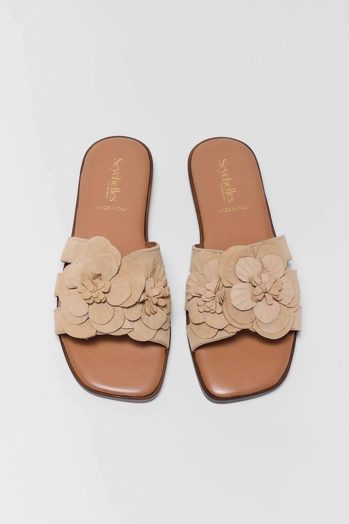 Tan suede women's slide sandals with floral appliqué strap, top-down view - Seychelles | Avara