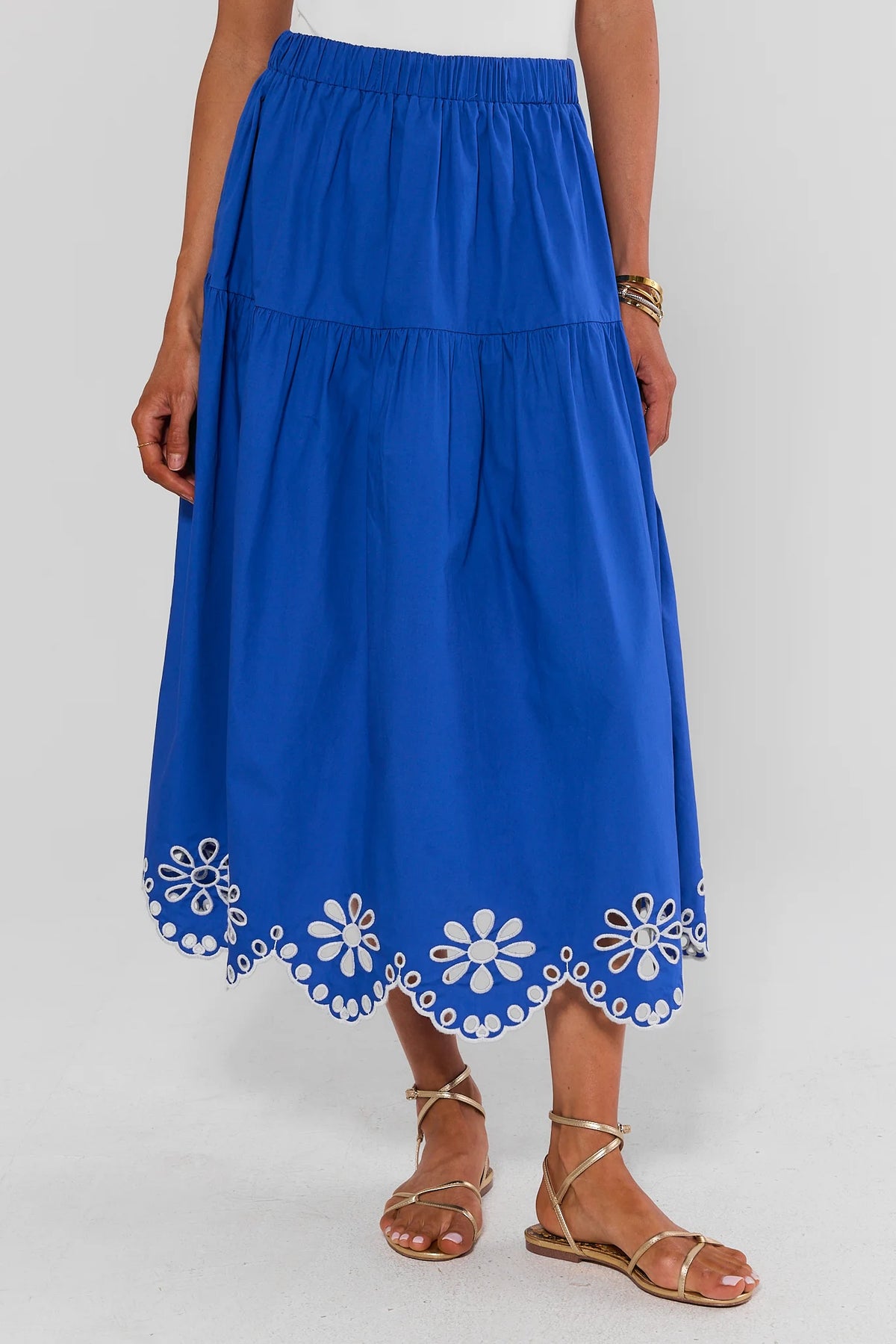 Blue skirt with white floral patterns at the bottom on a plain background