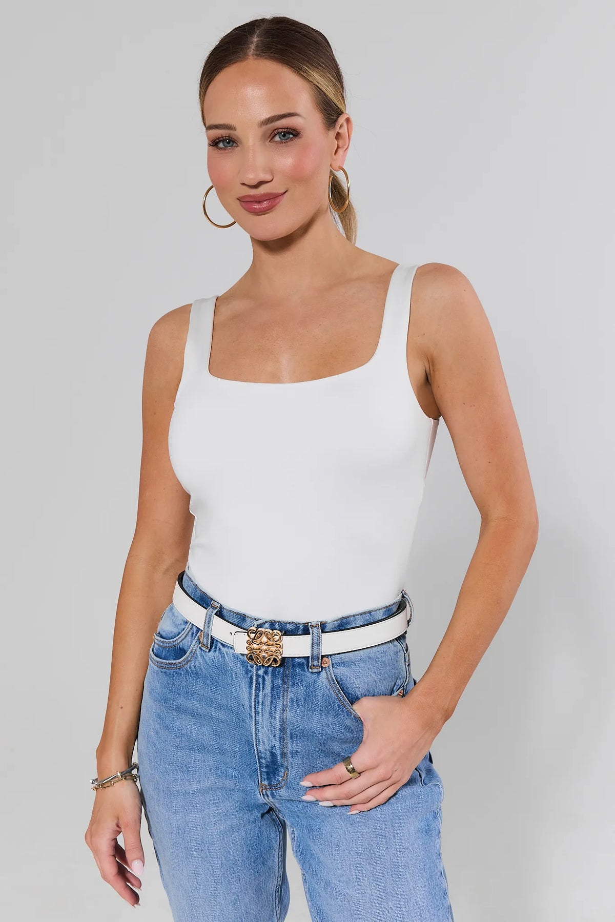 Rowan White Faux Leather Belt styled on model with white tank and blue jeans, gold buckle detail | Avara