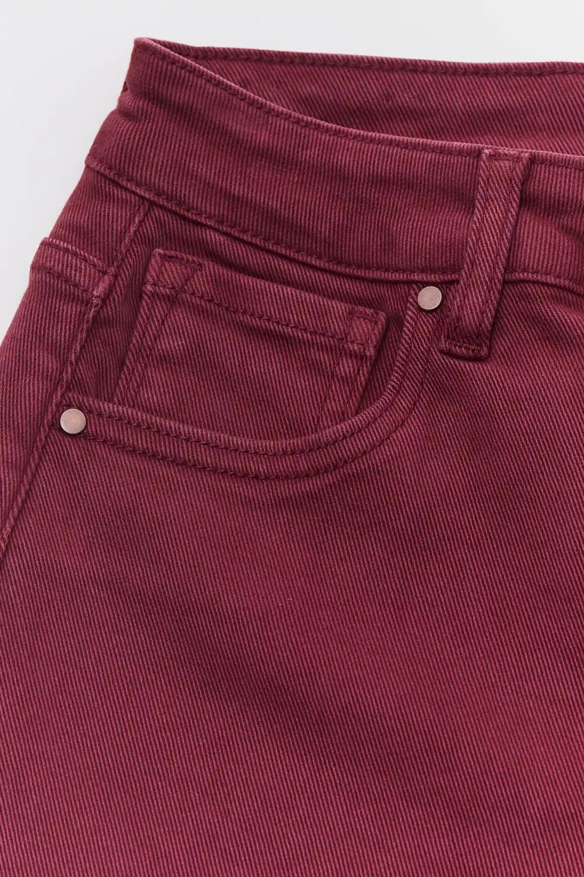 Burgundy Denim Jeans - Front Pocket & Hardware Close-Up Detail | Avara