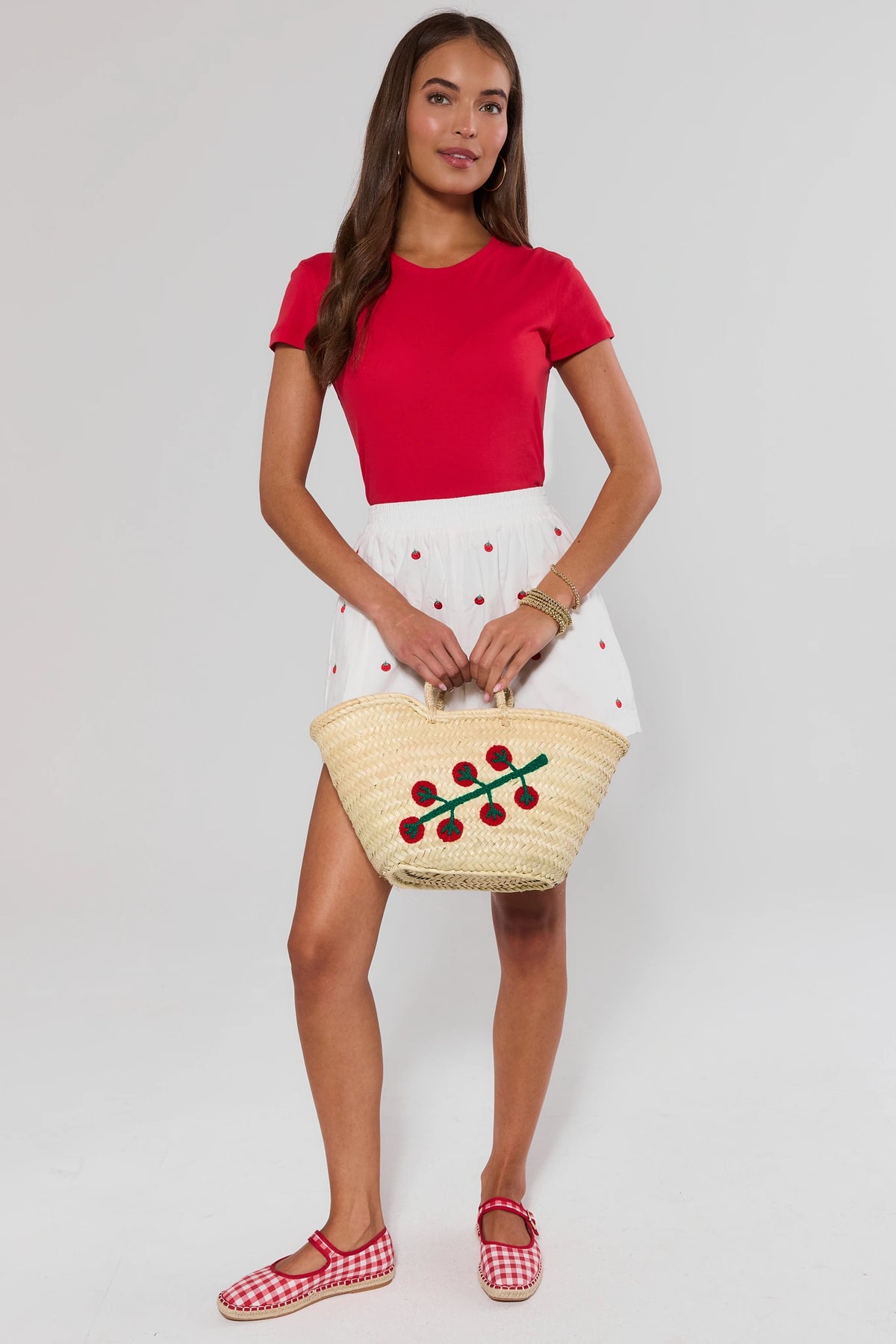 Woman holding tan woven crochet tote bag with tomato detail - On Model Styled Look | Avara