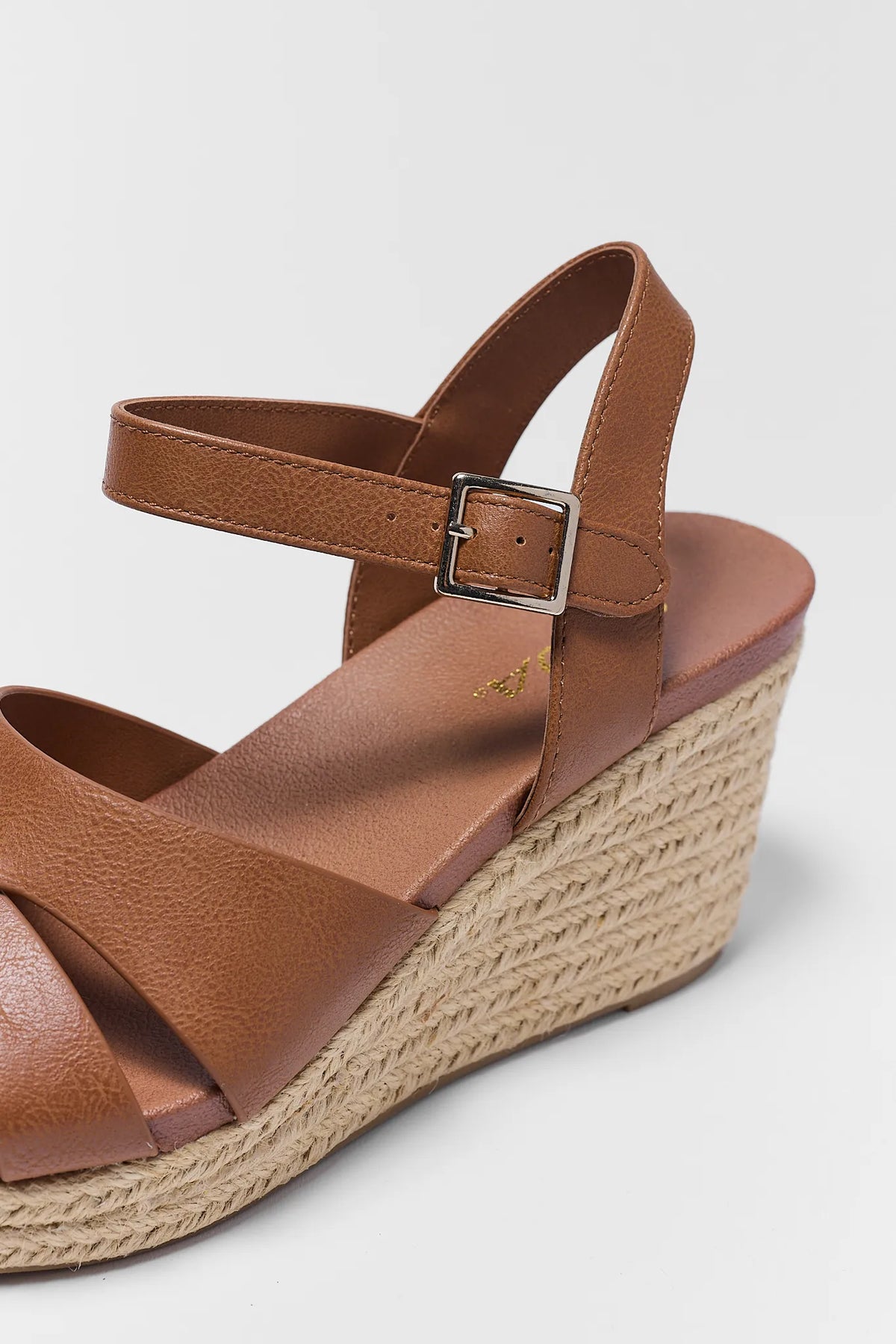 Brown espadrille wedge sandal close-up showing crossover straps and woven jute wedge detail | Avara