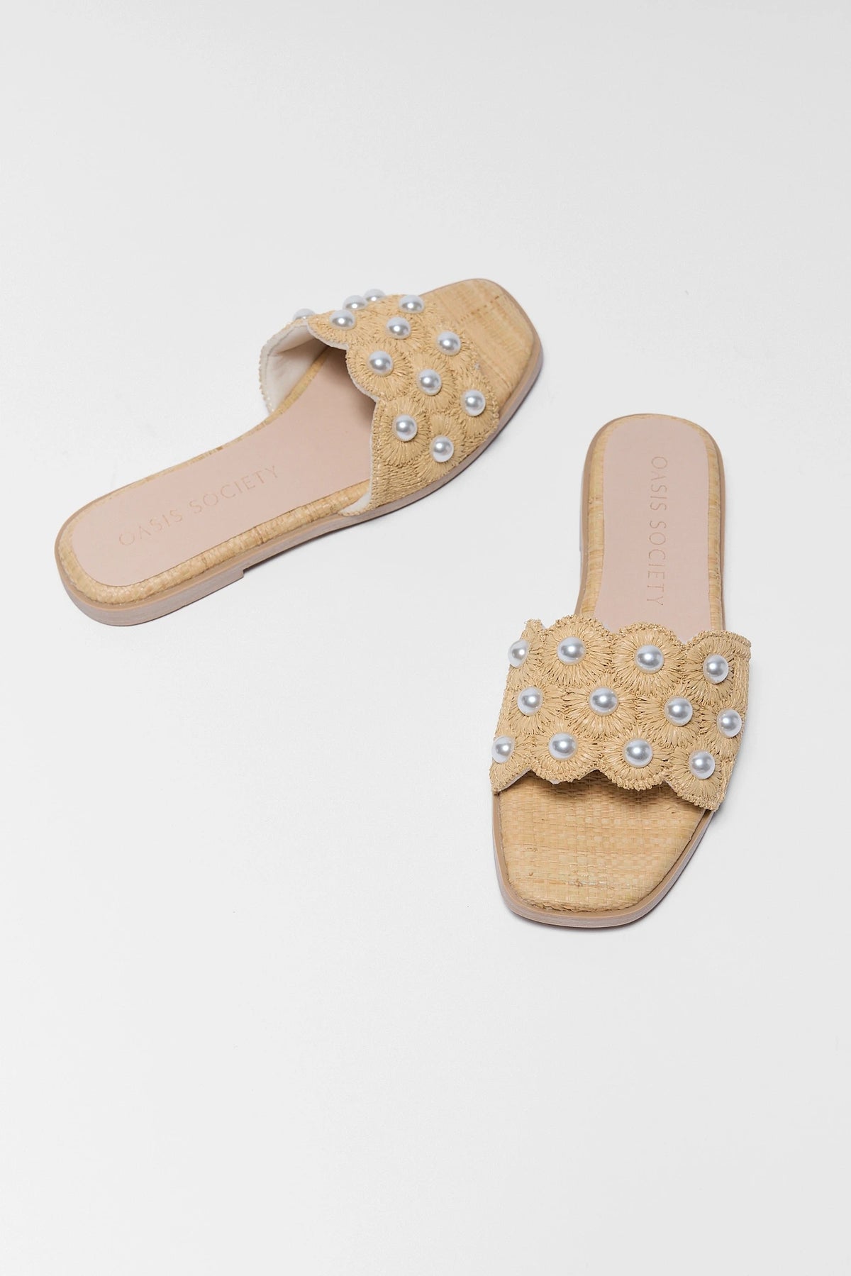 Tan raffia slide sandals with pearl embellishments, pair shown at angle - Oasis Society | Avara