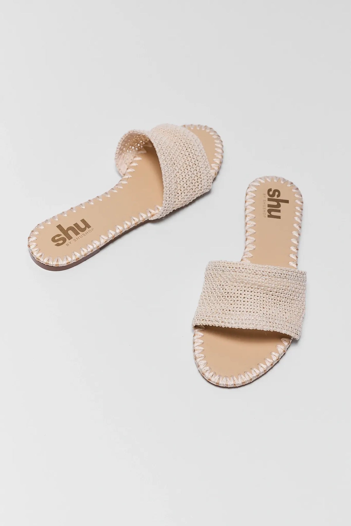 Tan Raffia Slide Sandal pair with woven strap and stitched trim, angled view | Avara