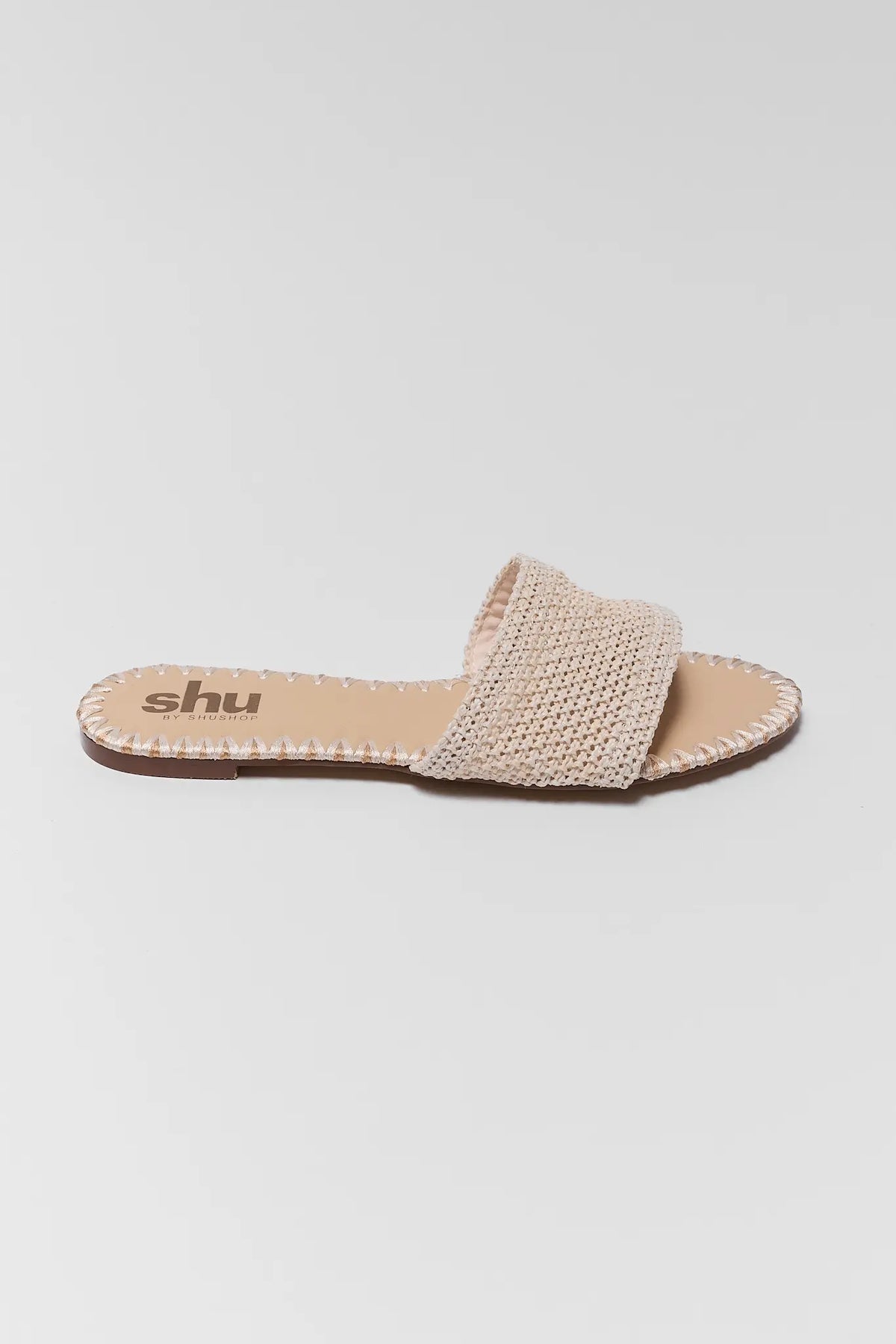 Tan Raffia Slide Sandal single shoe, woven strap with stitched edge, side profile | Avara