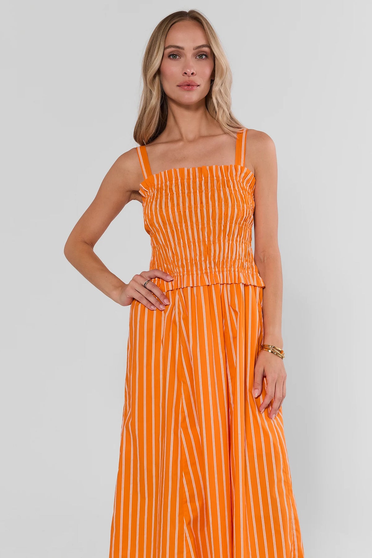 Orange striped smocked midi dress with smocked bodice and midi-length A-line skirt - Front View On Model | Avara