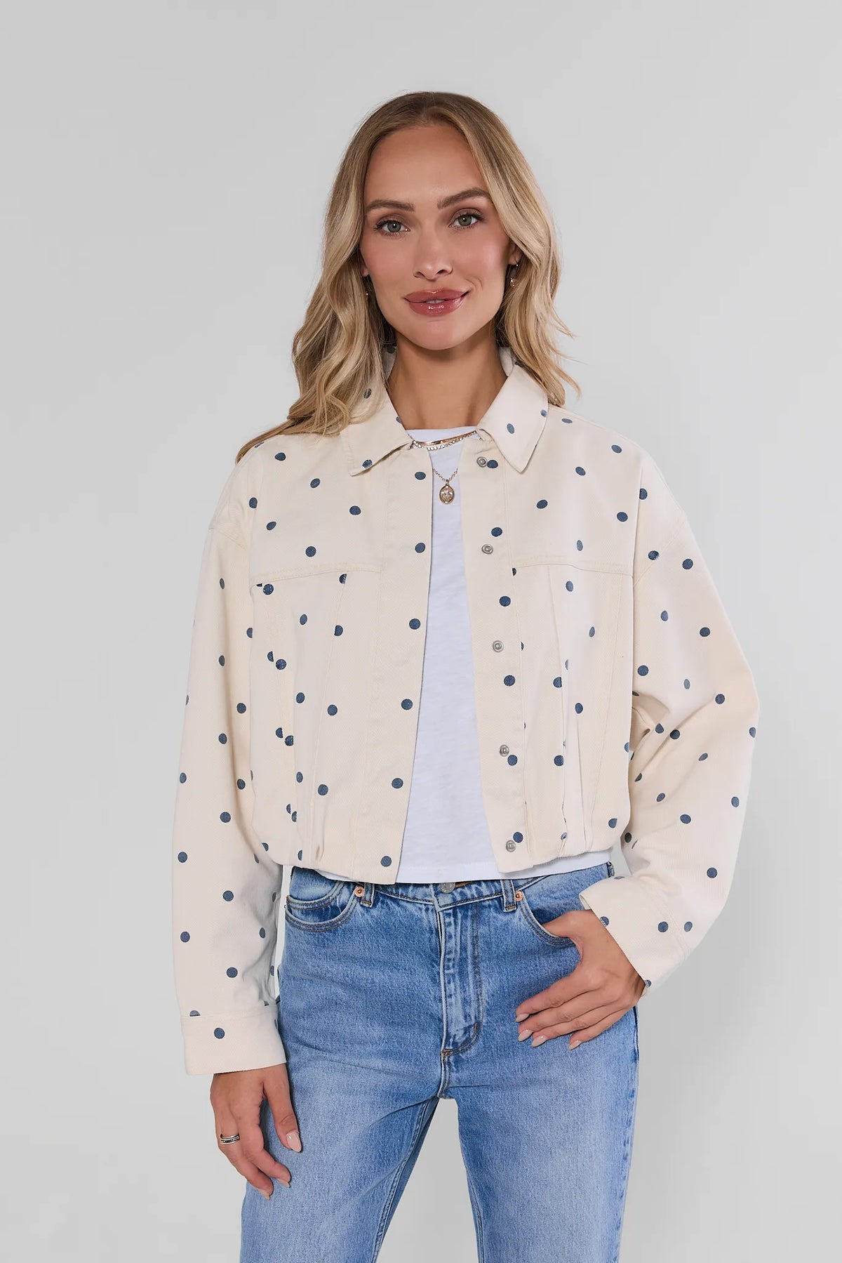 White Polka Dot Cropped Denim Jacket on model, front view, styled with white tee and blue jeans | Avara