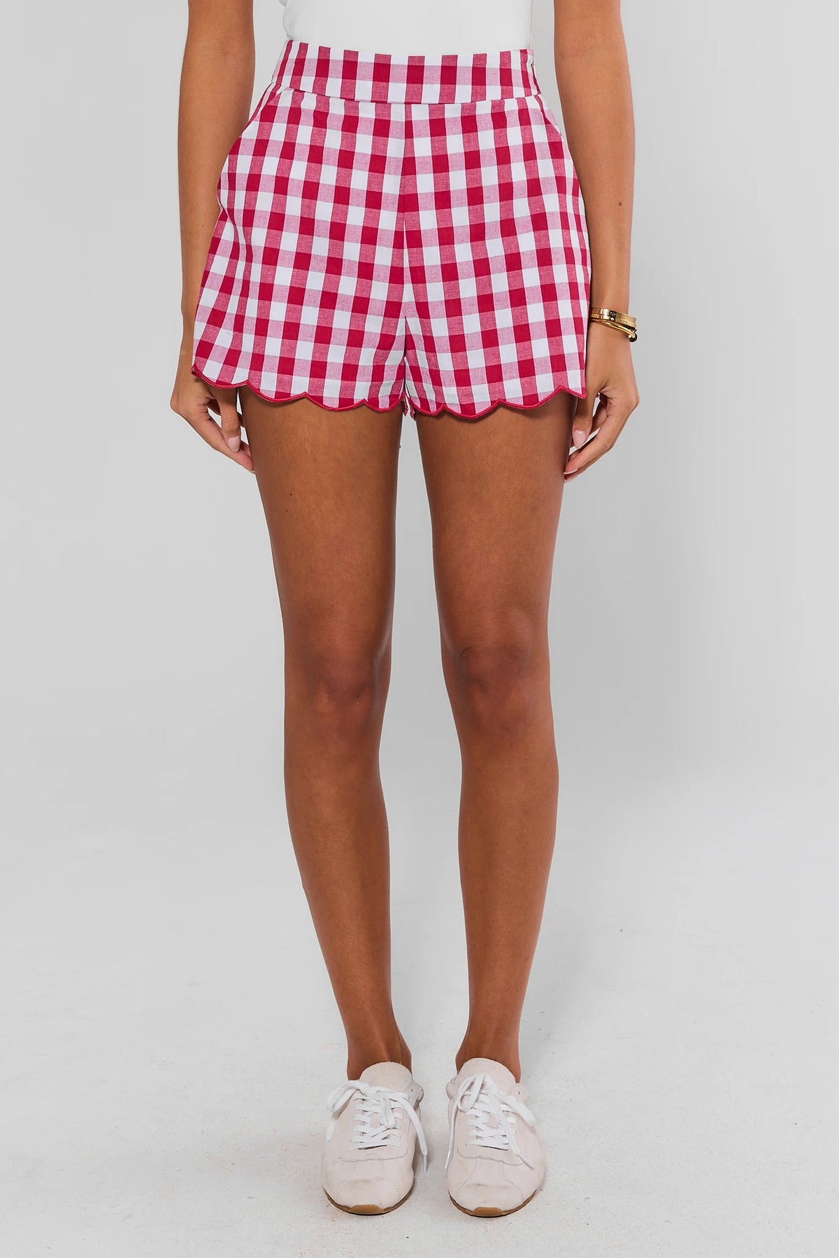 Women's red gingham scalloped shorts, front view on model with white top and sneakers | Avara